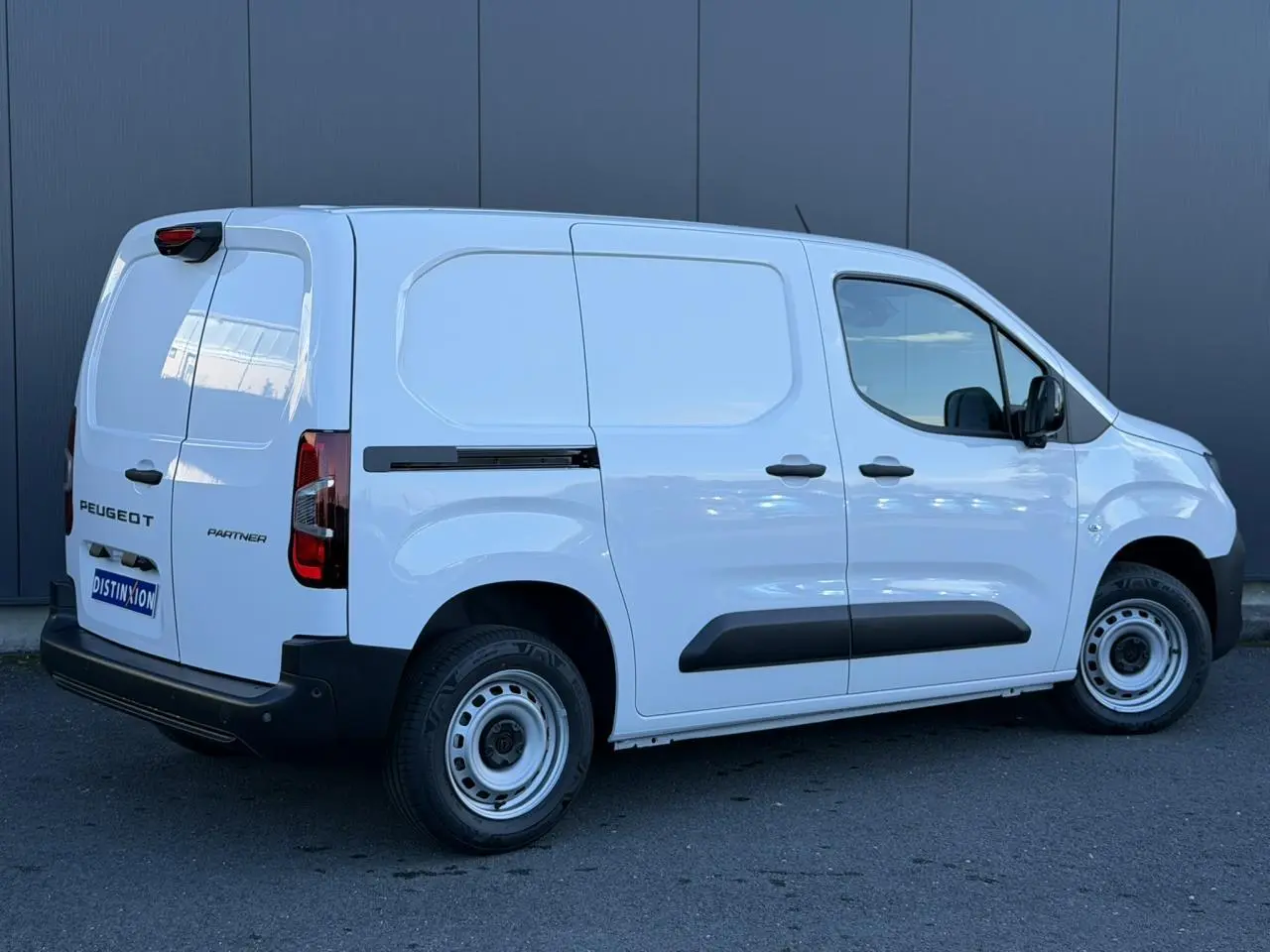 Vue 3/4 arrière droite du Peugeot Partner blanc Icy, fourgon utilitaire avec portes arrière battantes et porte latérale tôlée.