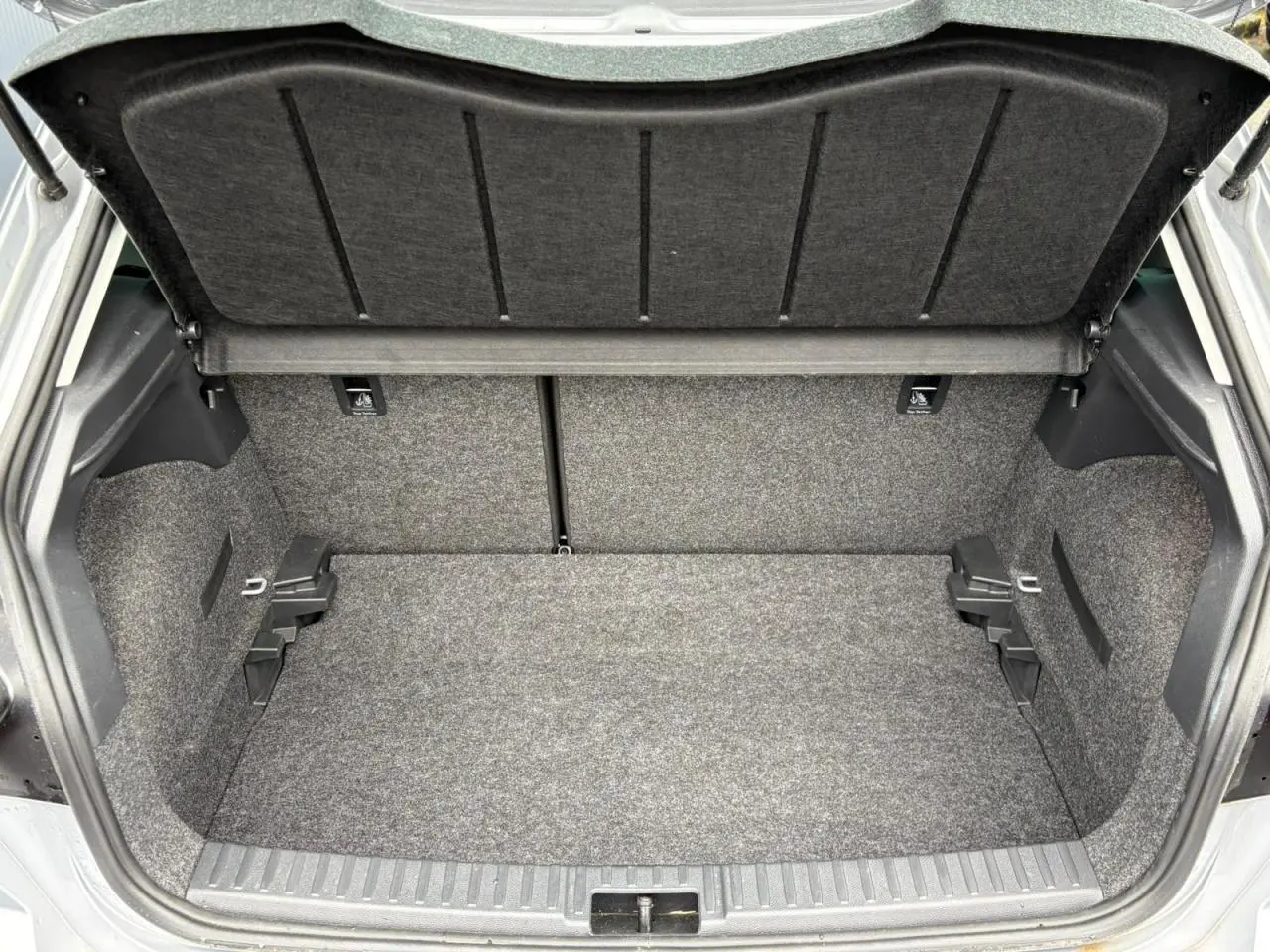 Coffre ouvert vu de face d’une SEAT Ibiza 2024 argent urbain, montrant un espace de chargement propre et spacieux.