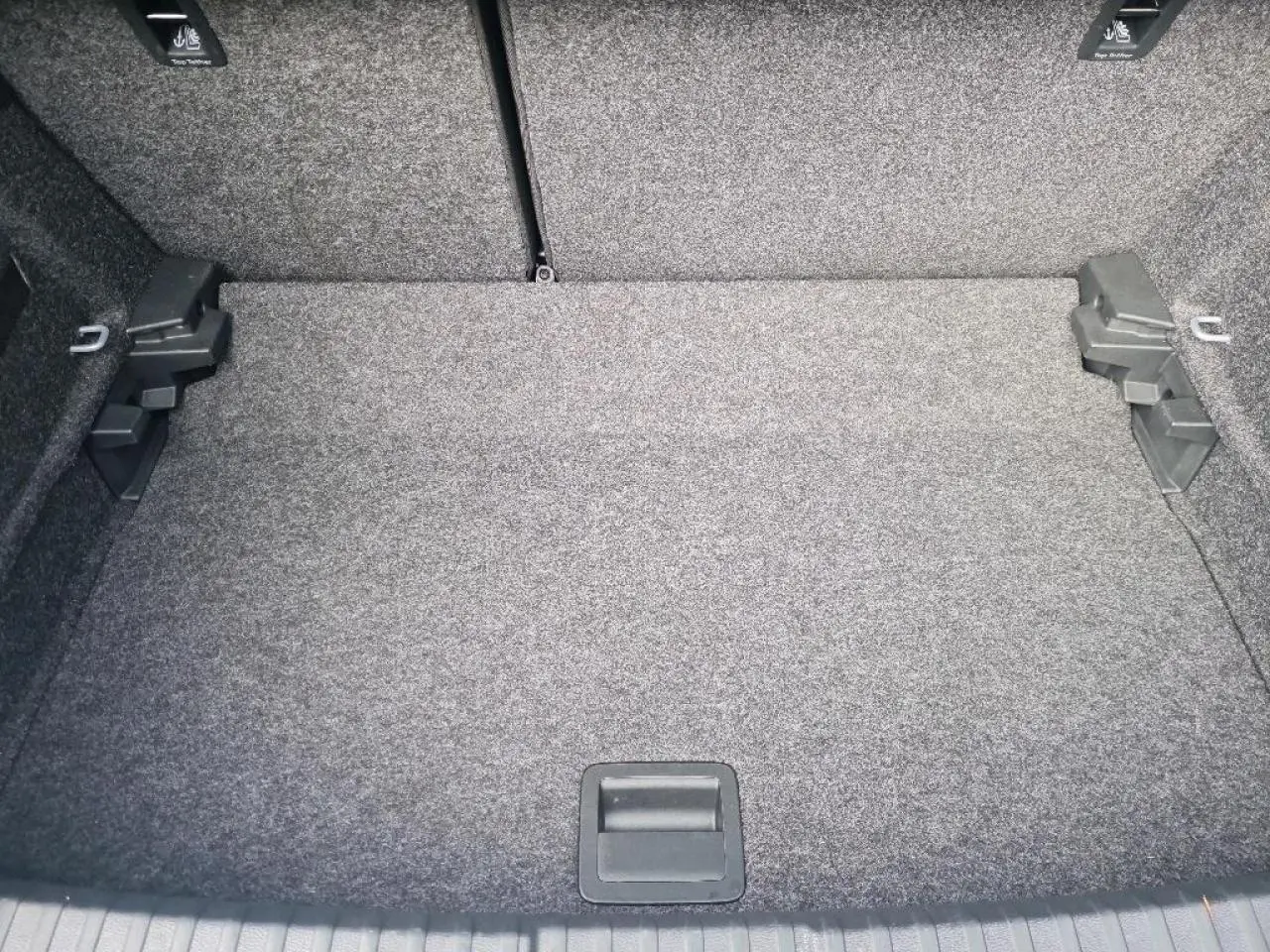 Coffre spacieux et propre de la SEAT IBIZA 2024, vue intérieure sans chargement, revêtement gris uniforme.