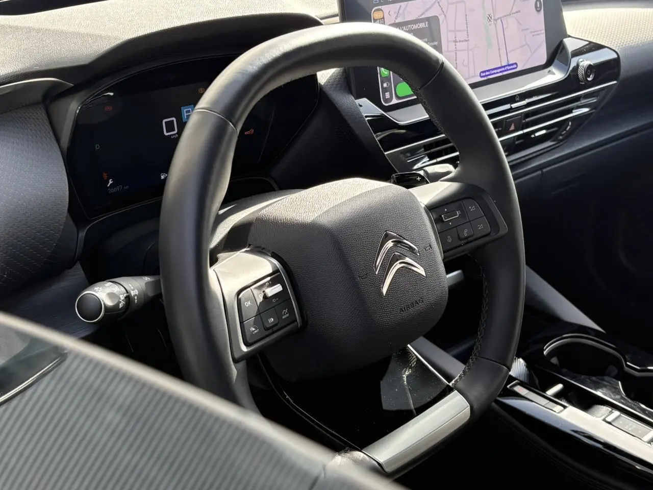 Vue rapprochée du volant cuir noir et du tableau de bord digital du Citroën C5 X 2024 avec écran tactile 12 pouces.