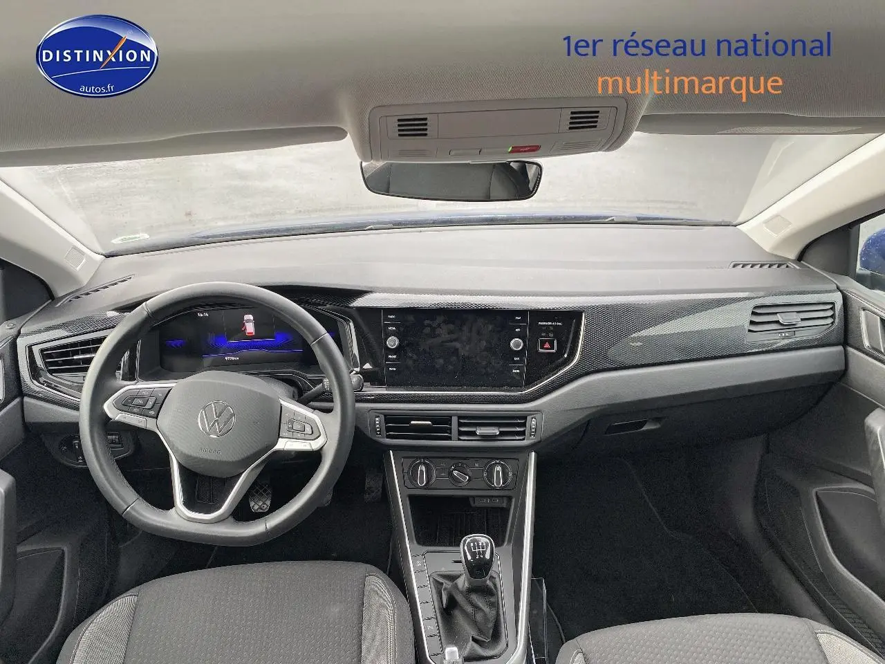 Vue intérieure avant du tableau de bord et volant cuir multifonction de la Volkswagen Polo bleu récif 2025 avec boîte manuelle.