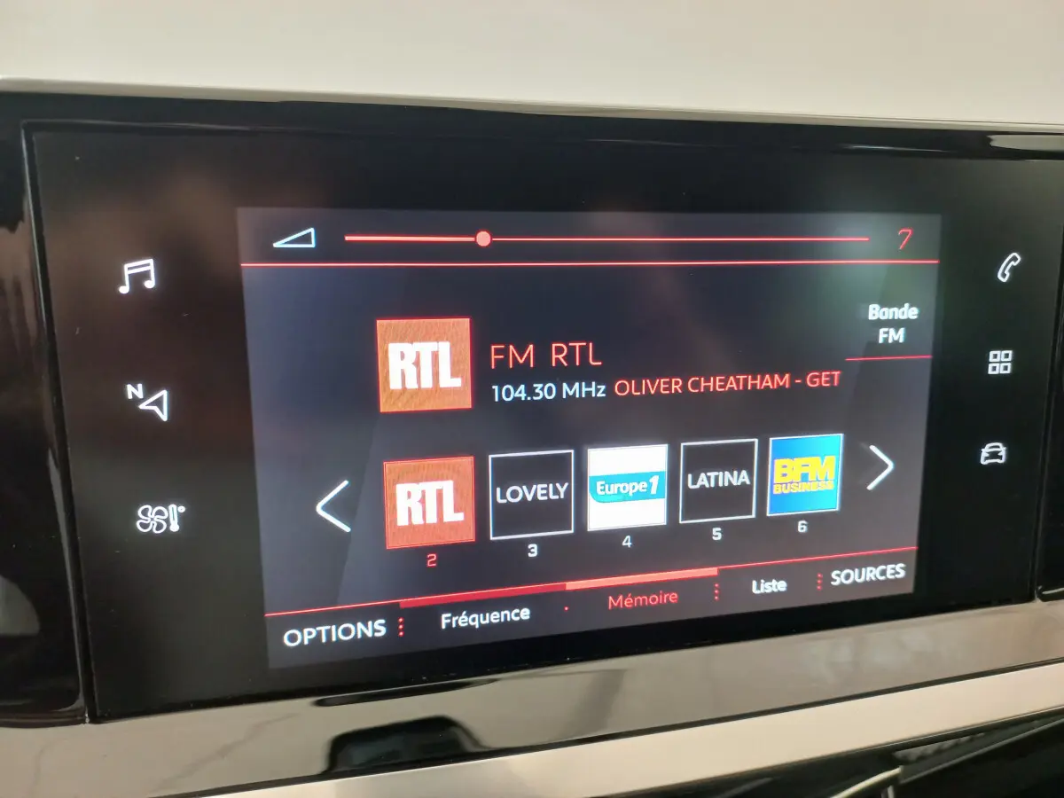 Écran tactile central de la Peugeot 208 PureTech 100 Allure affichant la radio FM RTL en intérieur noir.