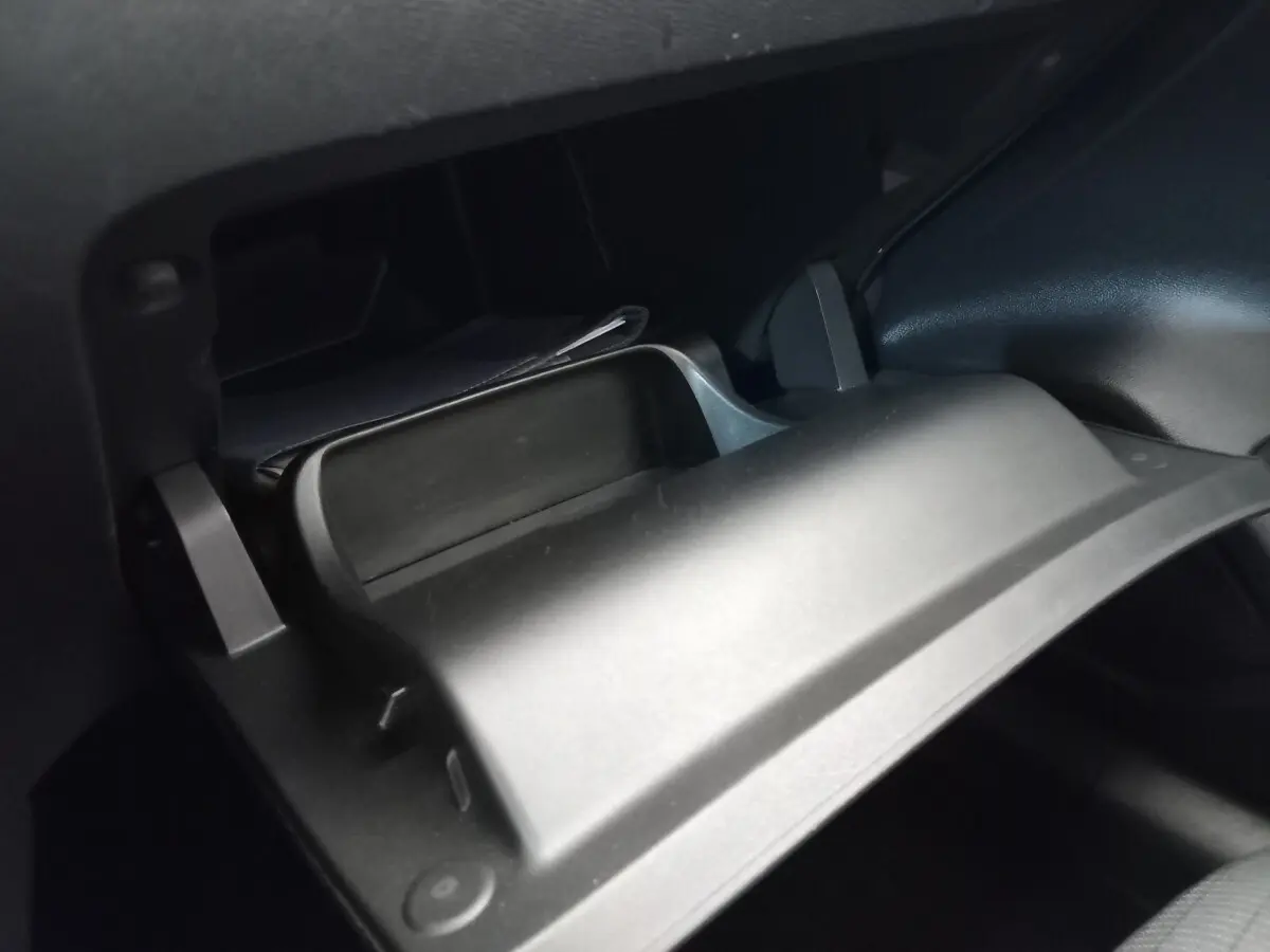 Gros plan sur la boîte à gants ouverte du Peugeot 208 PureTech 100 S&S Allure, intérieur noir.