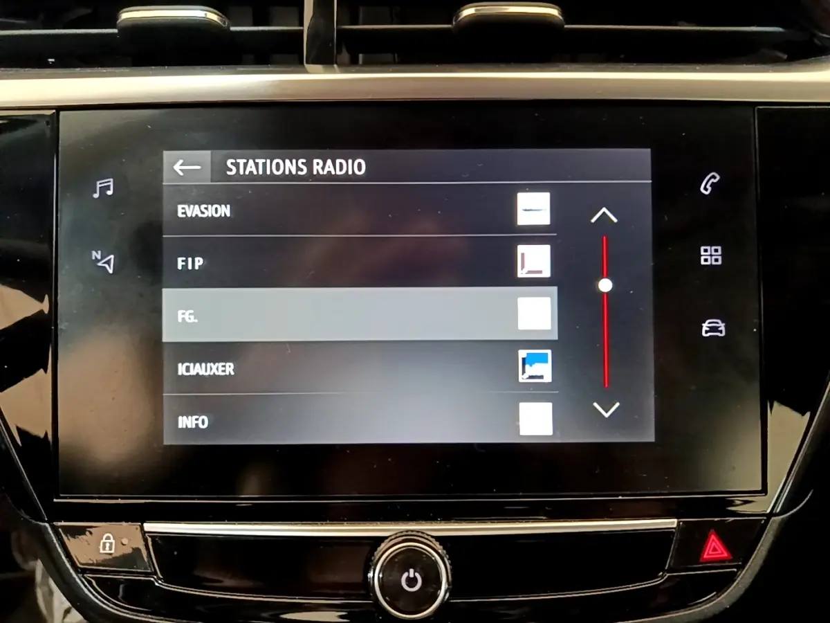 Écran tactile central de la console de l’Opel Corsa 2023 affichant les stations radio, interface noire brillante.