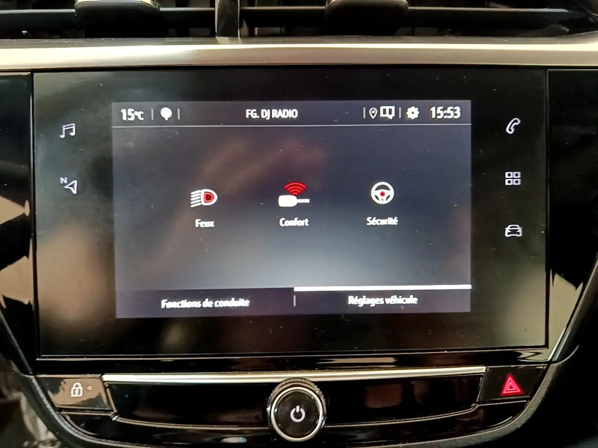 Écran tactile central de la console de l’Opel Corsa blanc, affichant les réglages feux, confort et sécurité.