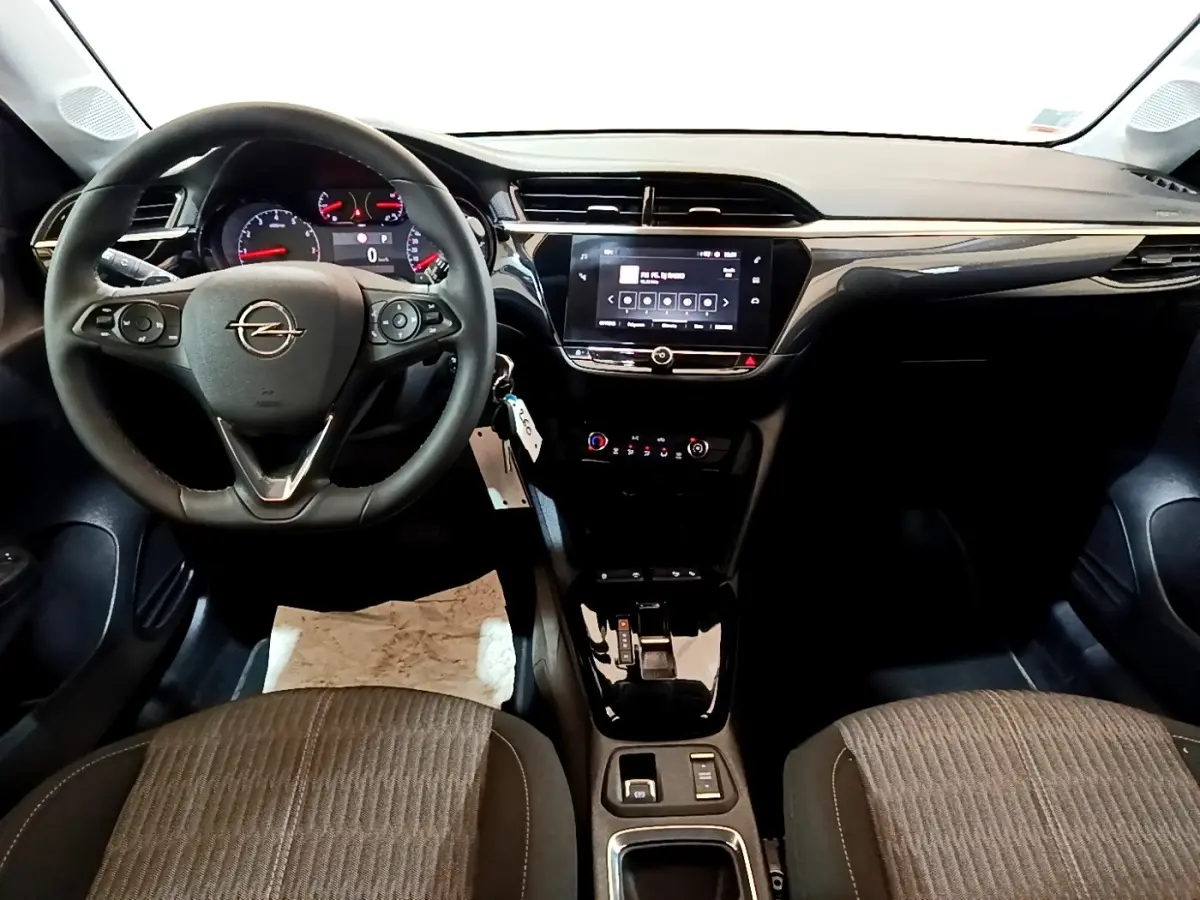 Vue intérieure avant de l’Opel Corsa 2023, tableau de bord noir avec écran tactile central et volant multifonctions cuir.