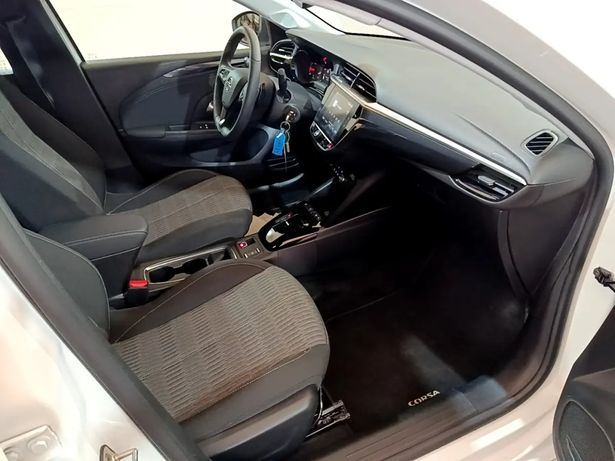 Intérieur avant droit de l’Opel Corsa blanc 2023, tableau de bord moderne avec écran tactile et sièges tissu gris.