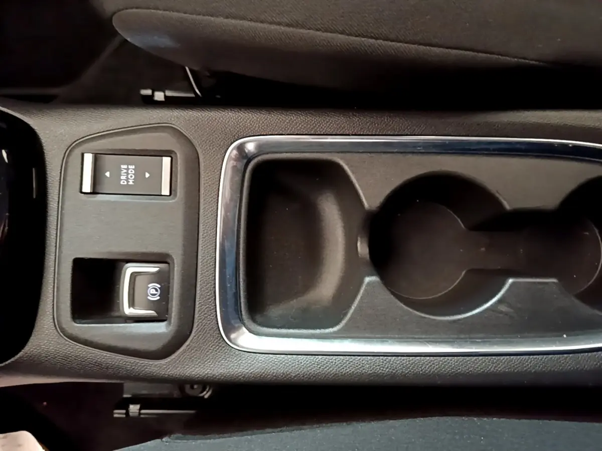 Vue rapprochée de la console centrale noire de l’Opel Corsa 2023 avec commandes Drive Mode et frein à main électrique.