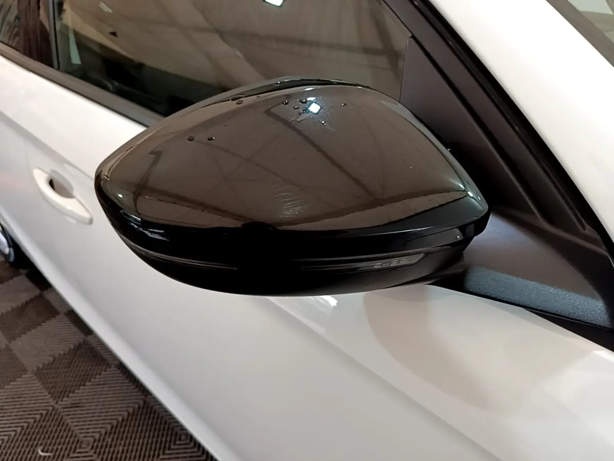Gros plan sur le rétroviseur extérieur noir côté gauche d'une Opel Corsa blanche 2023 vue de profil.