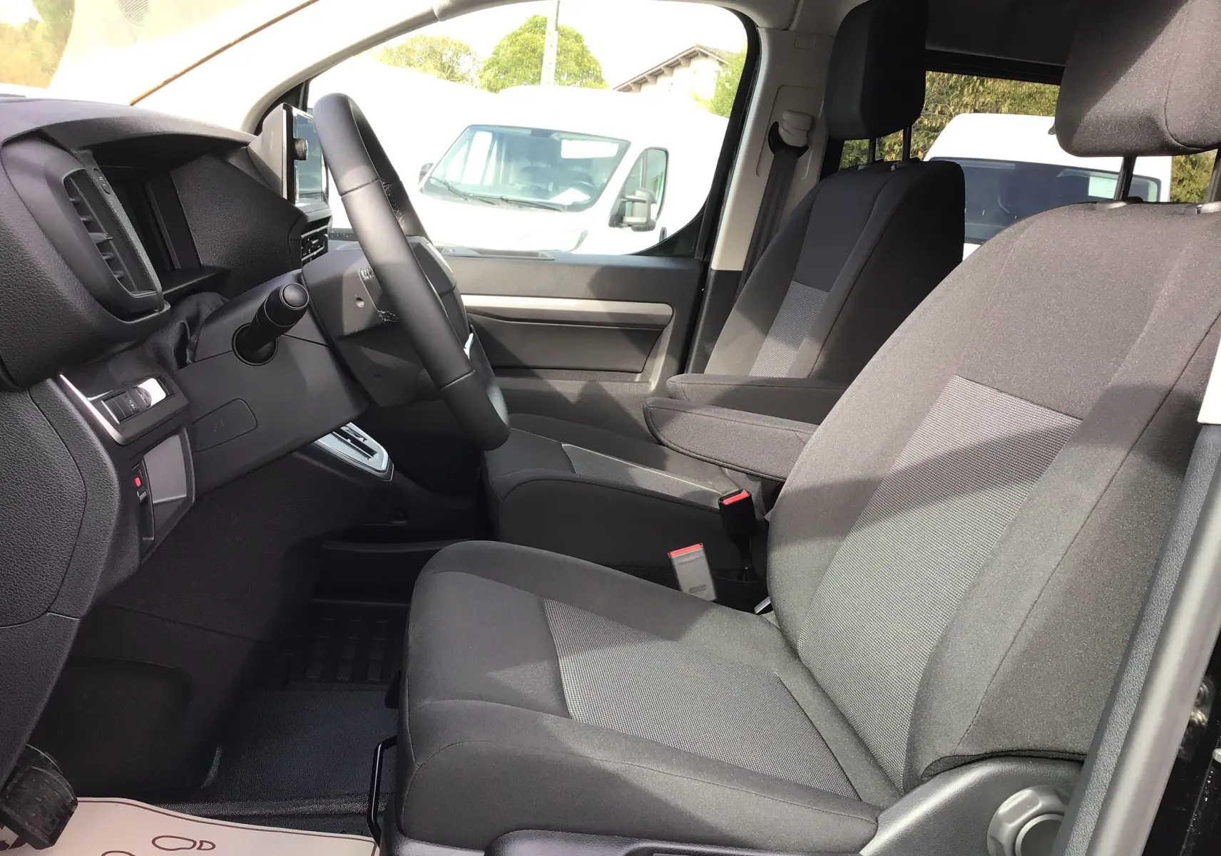 Vue intérieure côté conducteur du Peugeot Expert Cabine Approfondie noir, montrant les sièges avant et le tableau de bord.