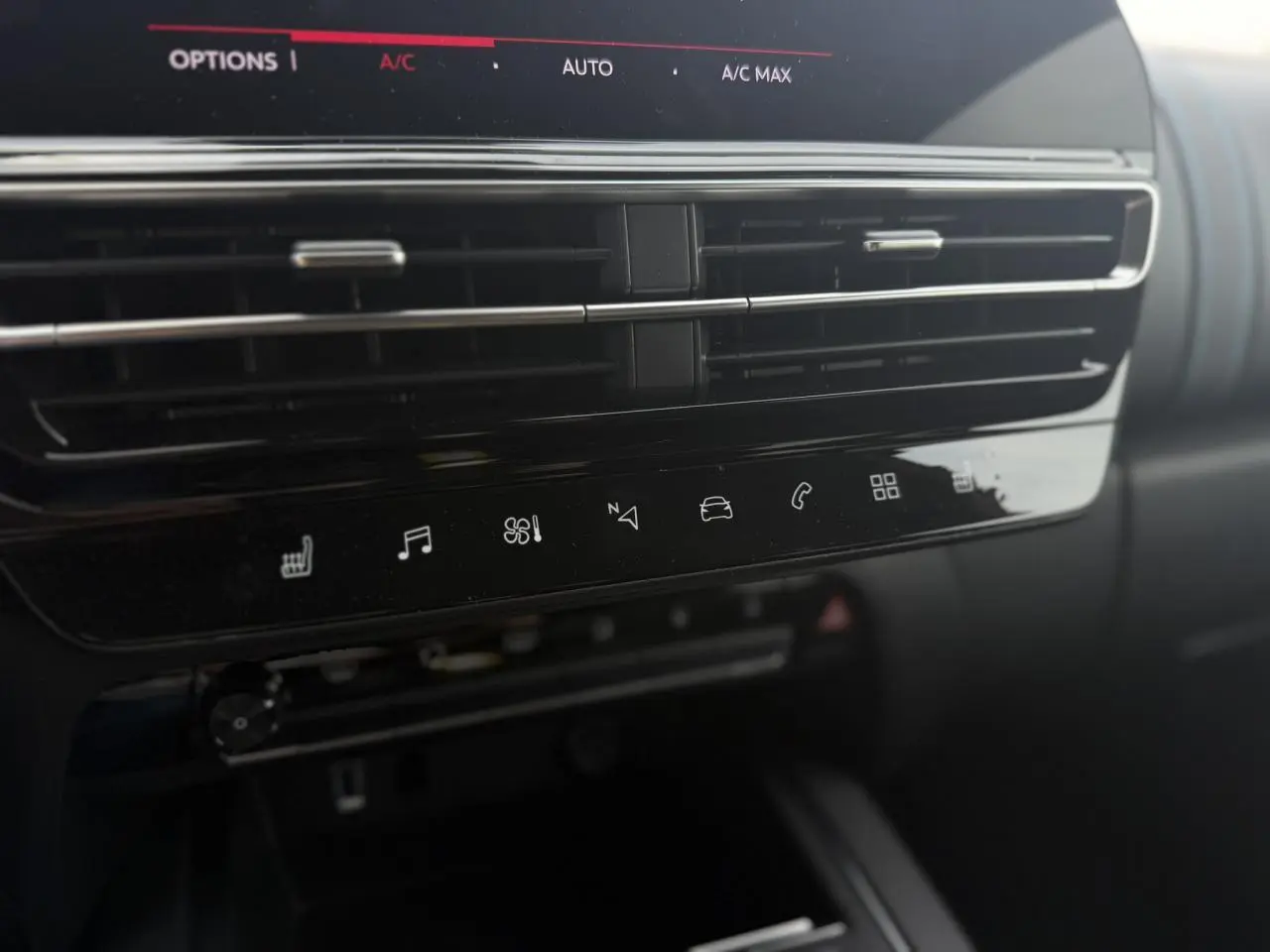 Vue rapprochée de la console centrale noire brillante du Citroën C5 Aircross 2025 avec commandes tactiles et aérateurs horizontaux.