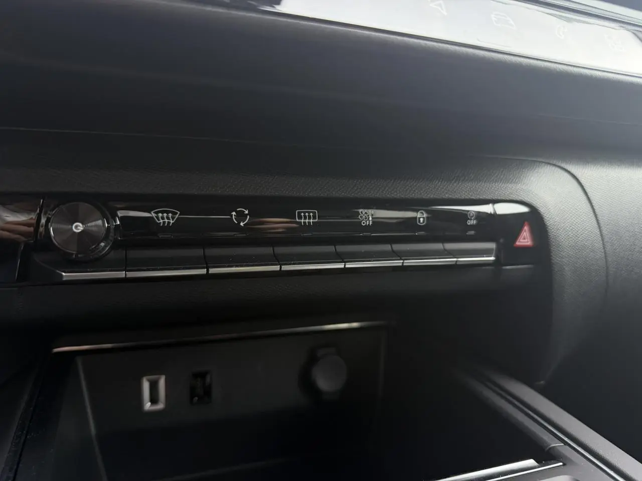 Vue rapprochée de la console centrale noire du Citroën C5 Aircross 2025 avec commandes climatisation et prise USB visible.