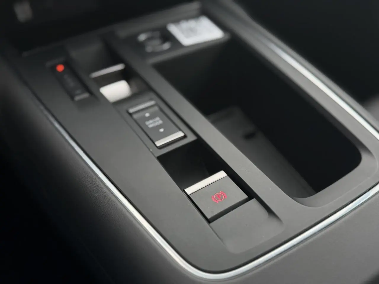 Gros plan sur la console centrale noire du Citroën C5 Aircross 2025 avec frein de stationnement électrique et commandes.