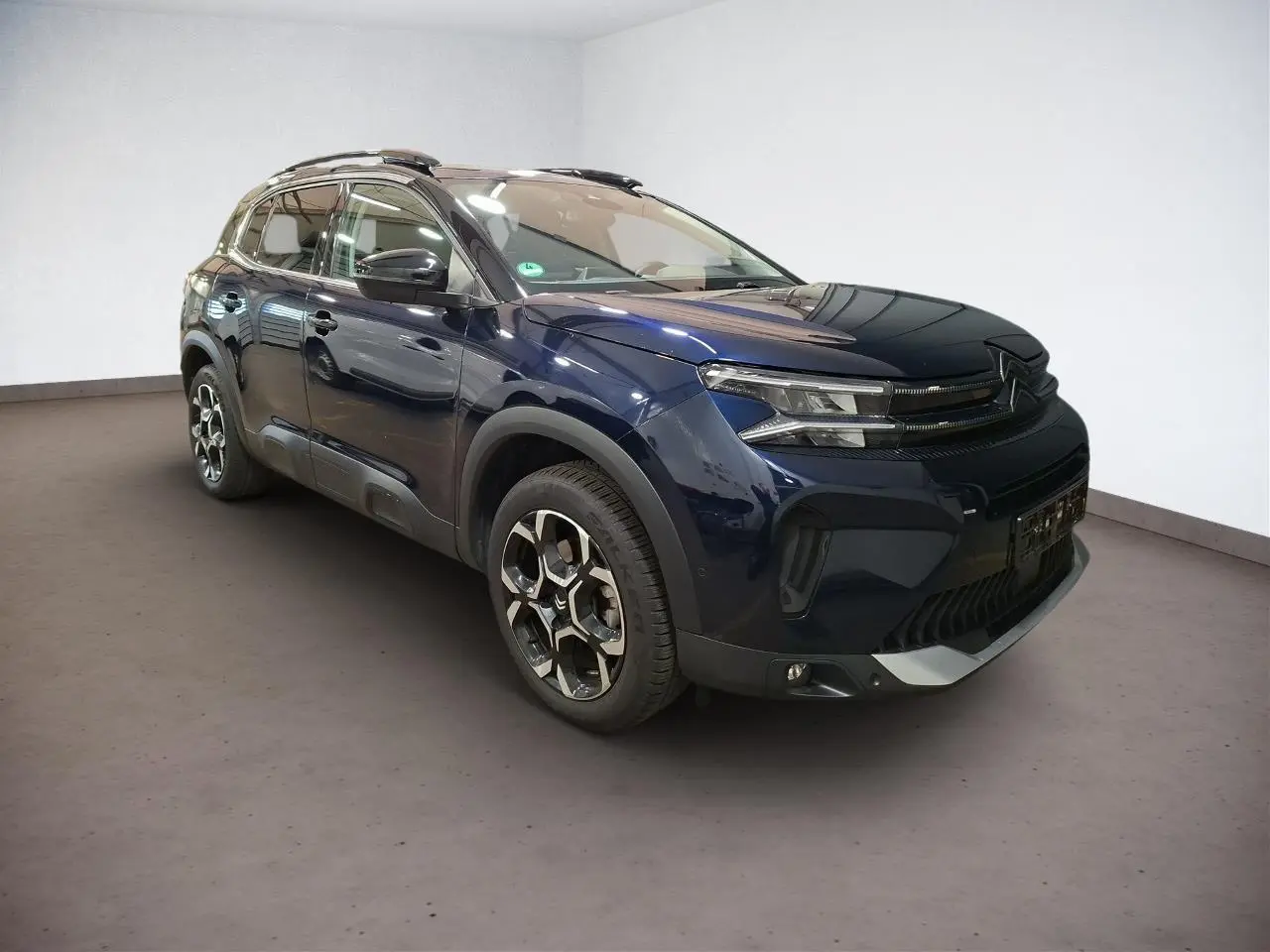 Citroën C5 Aircross Bleu Eclipse en 3/4 avant droit, avec jantes alliage bi-ton et barres de toit noires.