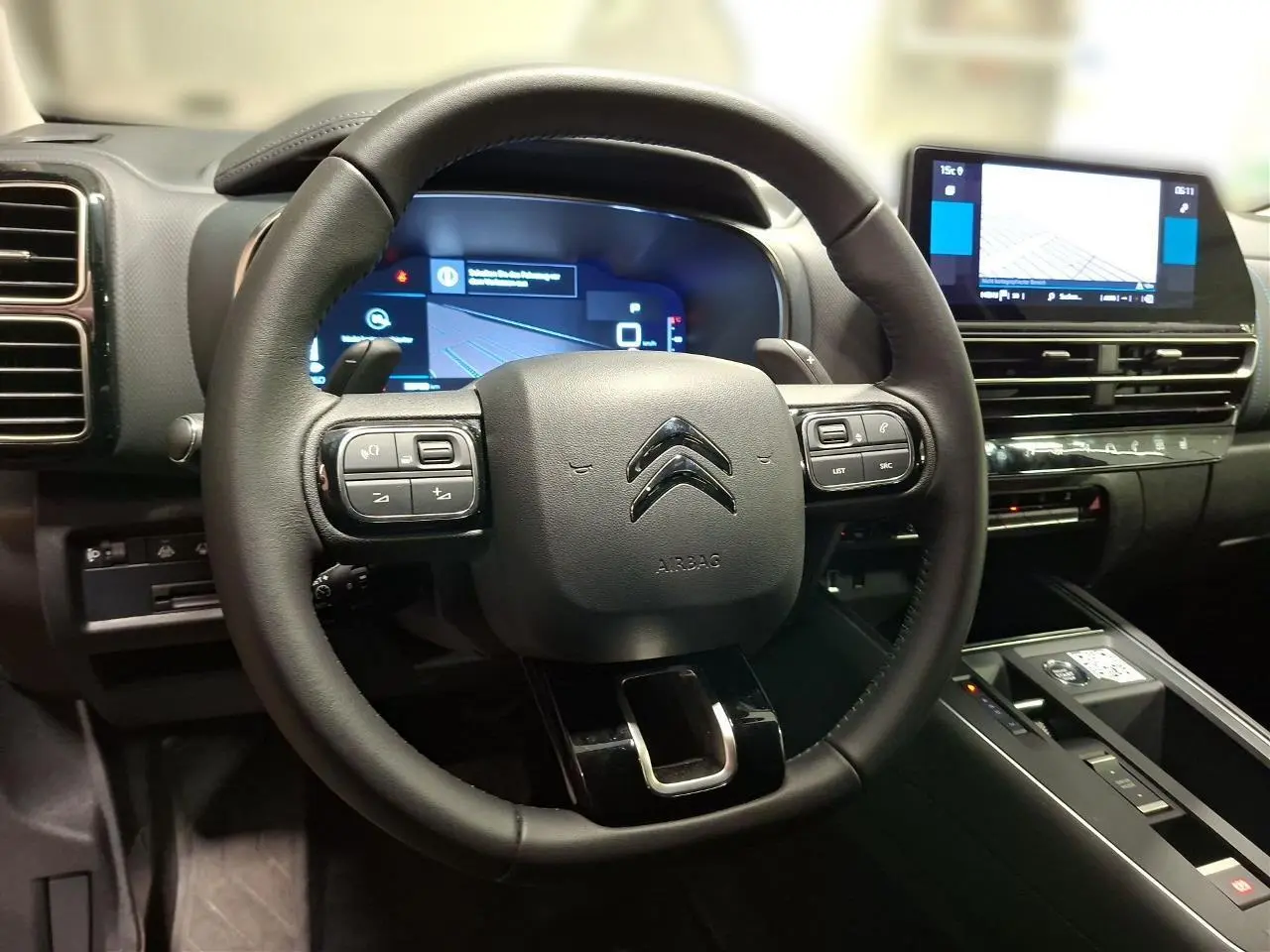 Vue rapprochée du volant cuir noir et du combiné numérique du tableau de bord du Citroën C5 Aircross 2025.