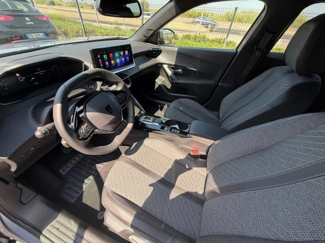 Intérieur du Peugeot 2008 Hybrid 145 e-DCS6 Allure 2025, vue côté conducteur, sièges gris et tableau de bord numérique.