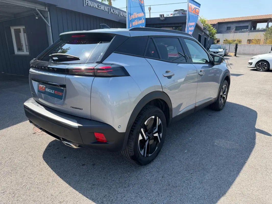 Vue 3/4 arrière droite du Peugeot 2008 Hybrid 145 gris avec feux arrière LED et jantes noires distinctives.