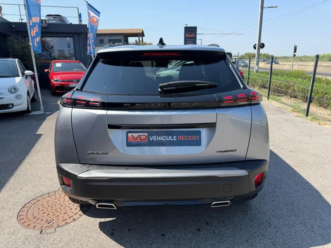 Vue arrière d'un Peugeot 2008 Hybrid gris 2025 avec feux arrière LED et double sortie d'échappement carrée.