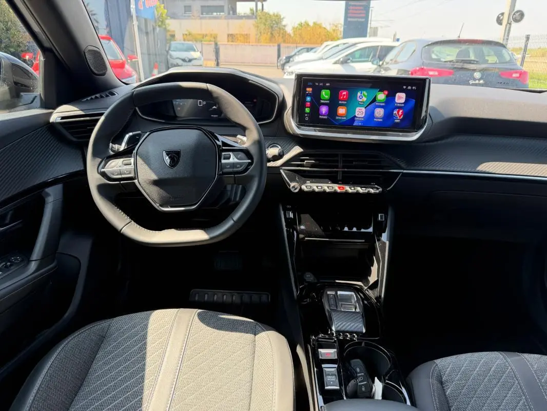 Vue intérieure de face du Peugeot 2008 Hybrid 145 e-DCS6 Allure 2025, avec tableau de bord noir et écran tactile central.