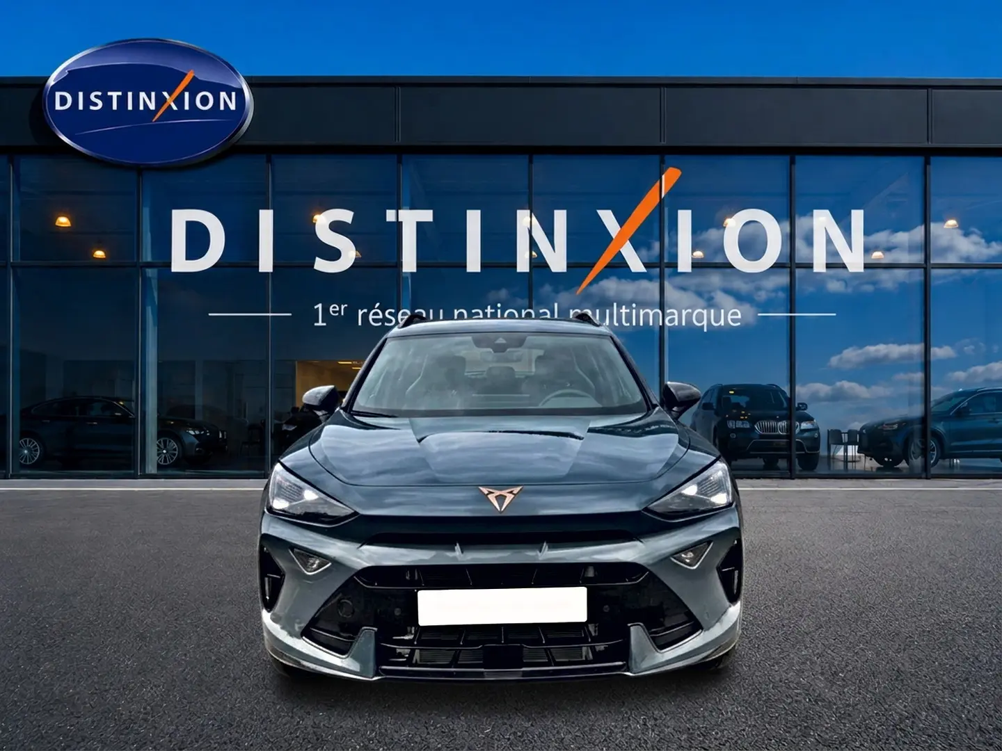Vue frontale d'un CUPRA Formentor 1.5 etsi hybrid bleu fjord avec logo distinctif cuivré sur calandre noire.