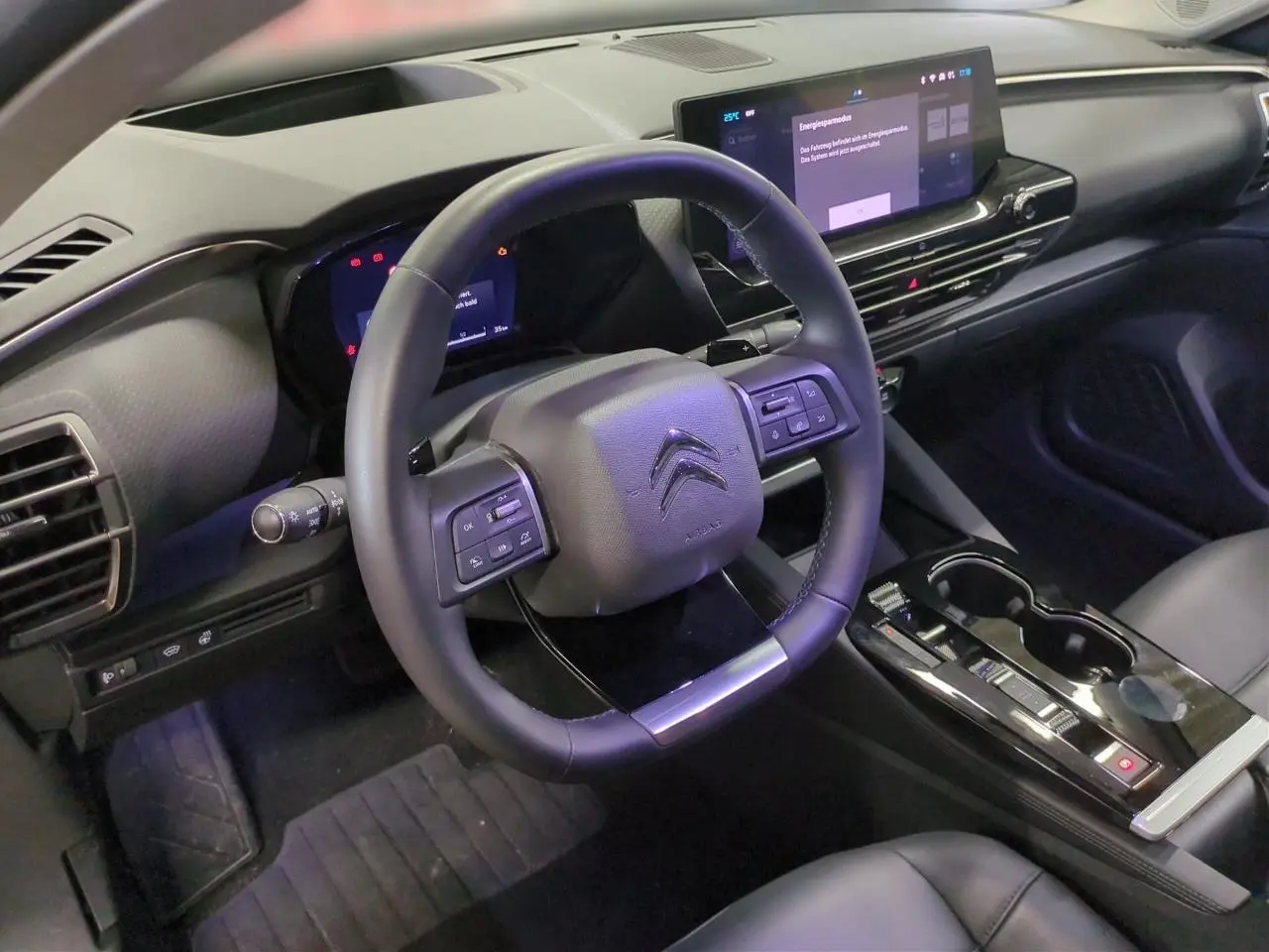 Intérieur du Citroën C5 X 2024 vu côté conducteur, volant cuir noir avec commandes intégrées et écran tactile 12 pouces.
