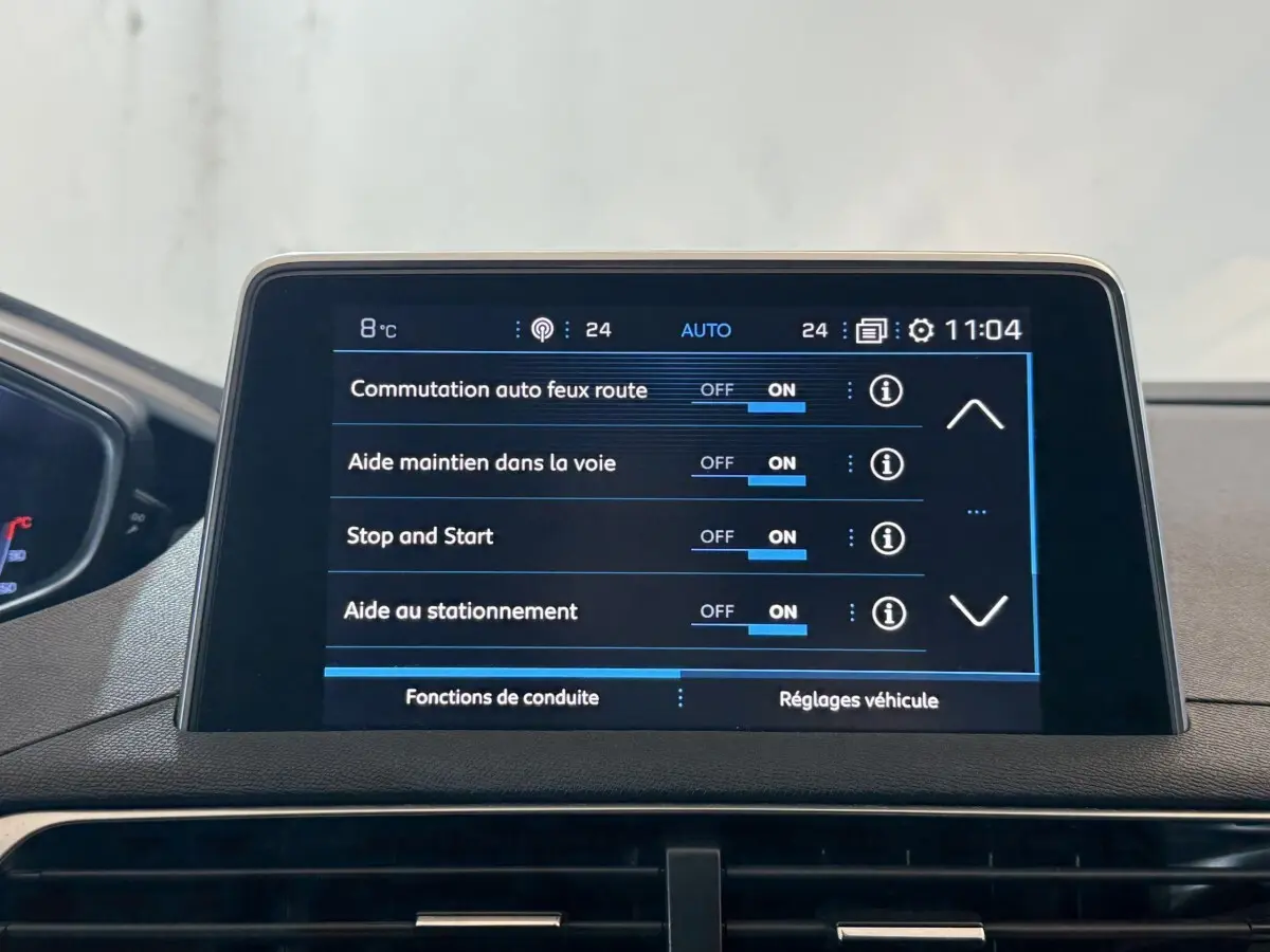 Écran tactile central du tableau de bord du Peugeot 3008 vert, affichant les réglages d'aides à la conduite.