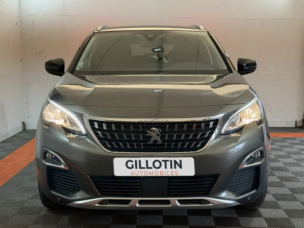 Vue frontale d'un Peugeot 3008 vert 2020 avec phares allumés et calandre noire distinctive.