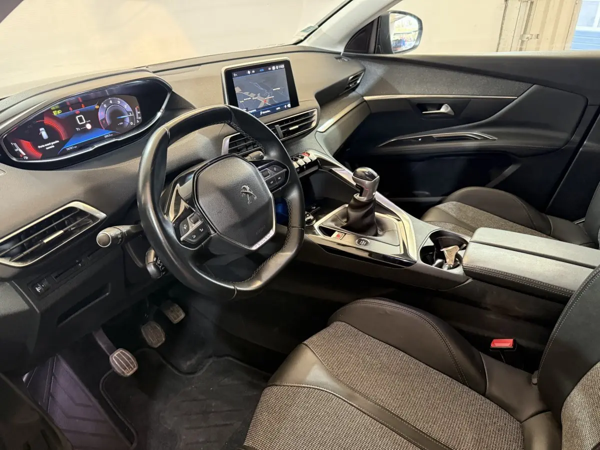 Vue intérieure côté conducteur du Peugeot 3008 vert 2020, volant cuir, écran tactile central et boîte manuelle.