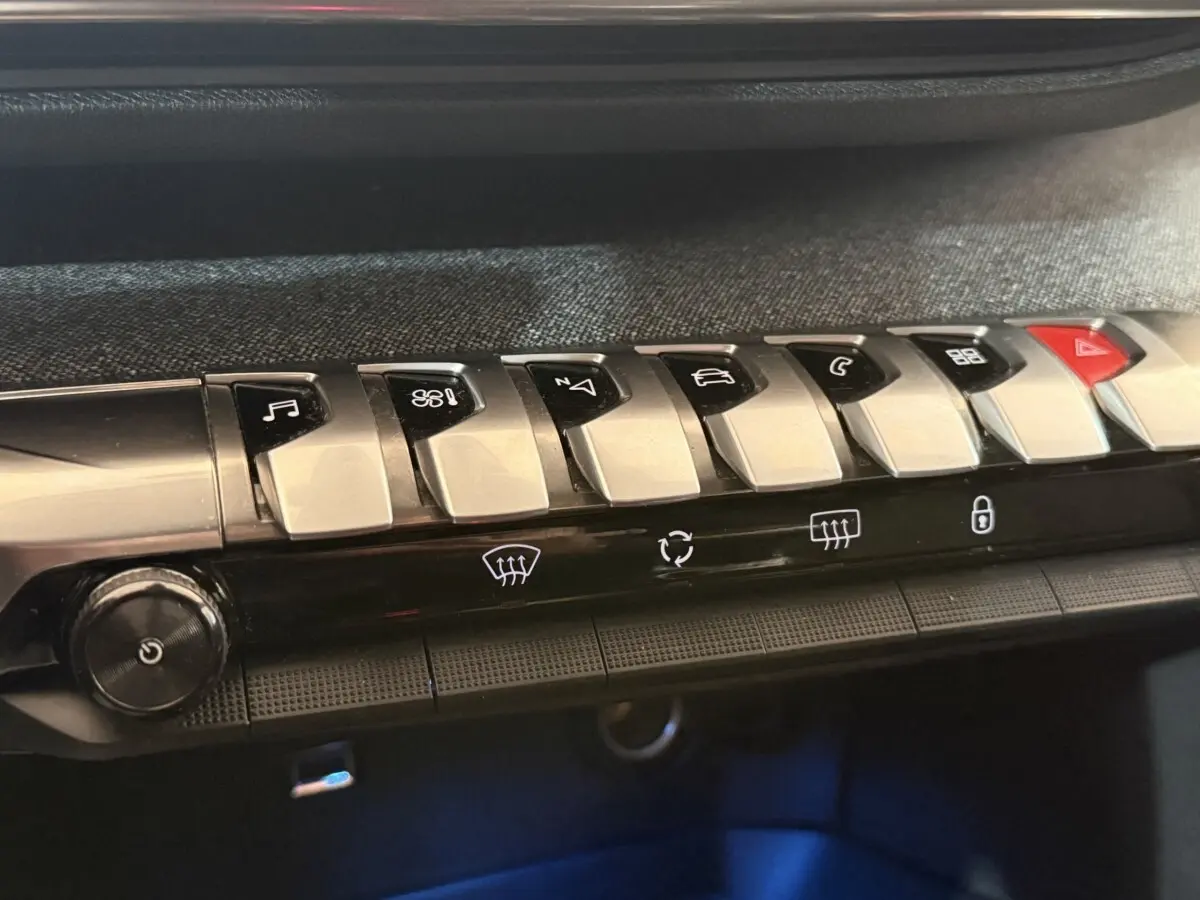 Gros plan sur les commandes piano noires et argent du tableau de bord du Peugeot 3008 vert, version Puretech 130 S&S Allure.