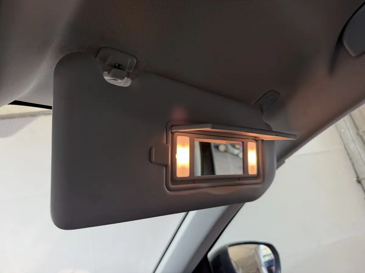 Détail du pare-soleil côté conducteur avec miroir éclairé dans l’habitacle d’un Peugeot 3008 vert.