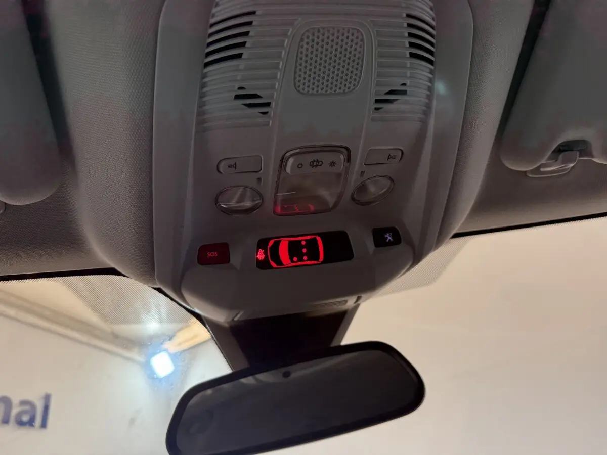 Vue en contre-plongée du plafonnier avec commandes et affichage rouge du système d’alerte du Peugeot 3008 vert Puretech 130.