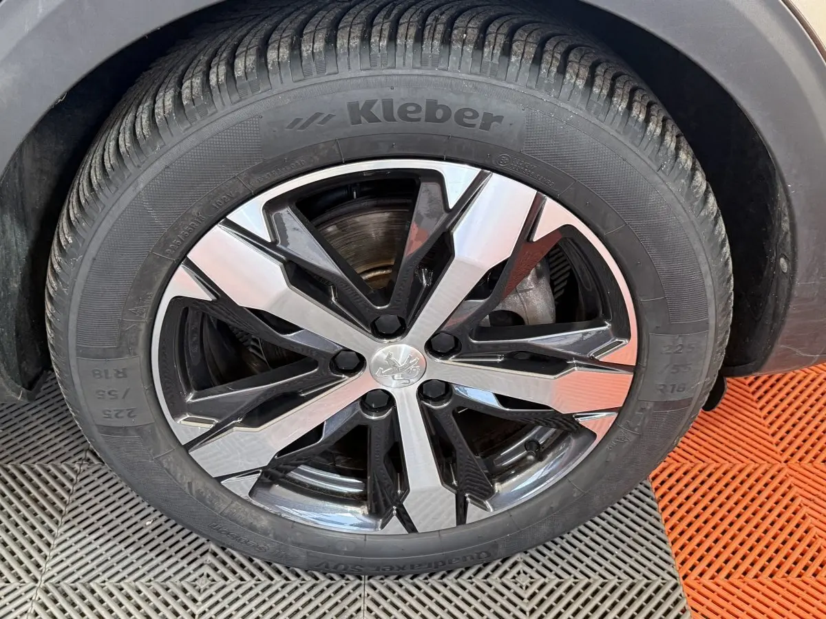 Gros plan sur la jante avant droite du Peugeot 3008 vert, avec pneu Kleber et design en alliage bicolore noir et argent.