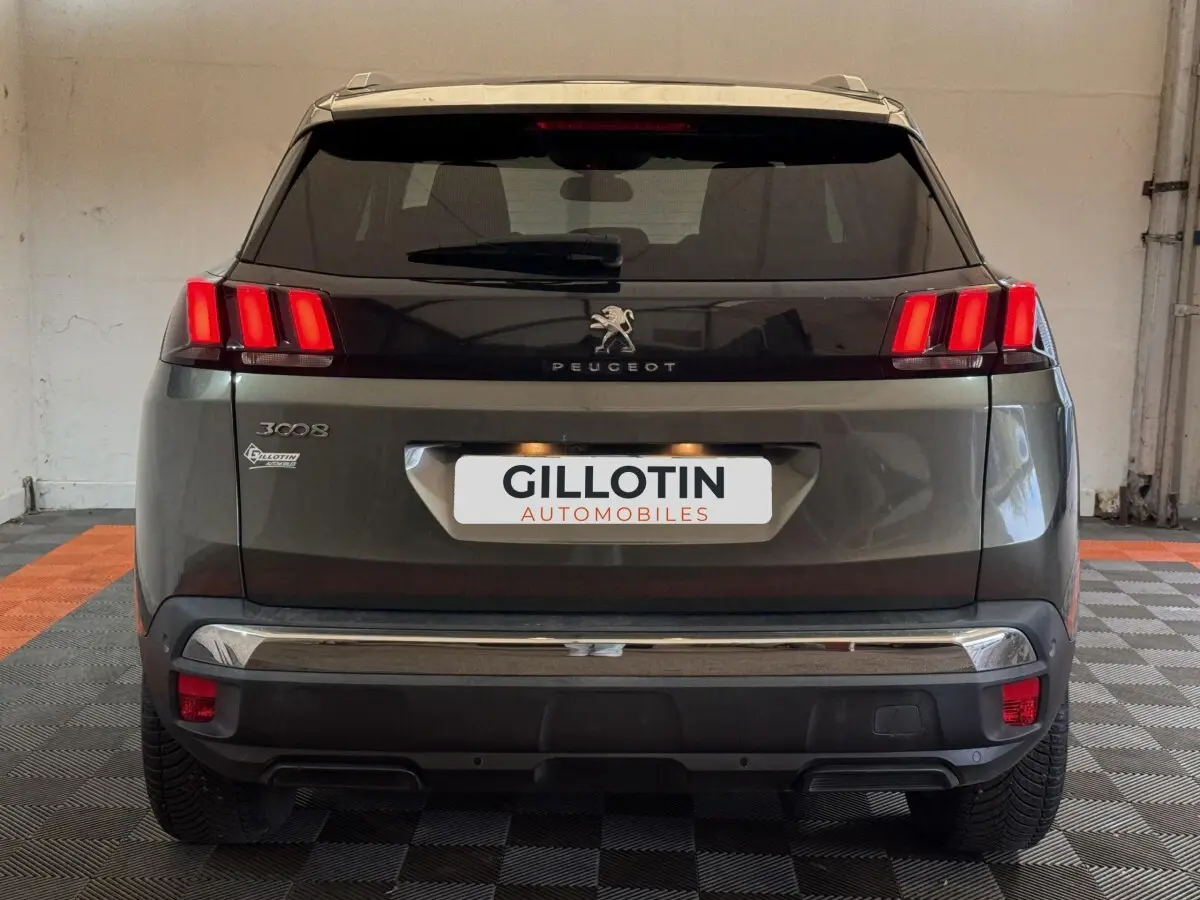 Vue arrière d'un Peugeot 3008 vert avec feux arrière à trois griffes rouges et logo lion central.