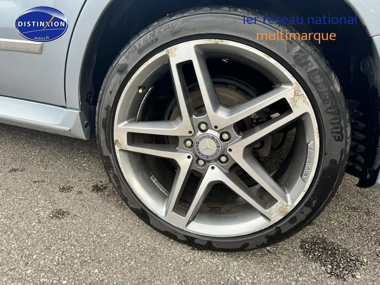 Gros plan sur la jante alu AMG argentée du côté avant droit d'une Mercedes GLK 350 4matic noire de 2014.