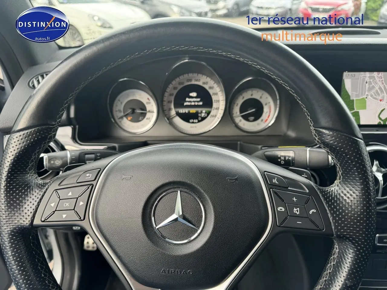 Vue rapprochée du volant cuir multifonction noir d’un Mercedes GLK 350 4matic avec tableau de bord et écran de navigation visible.