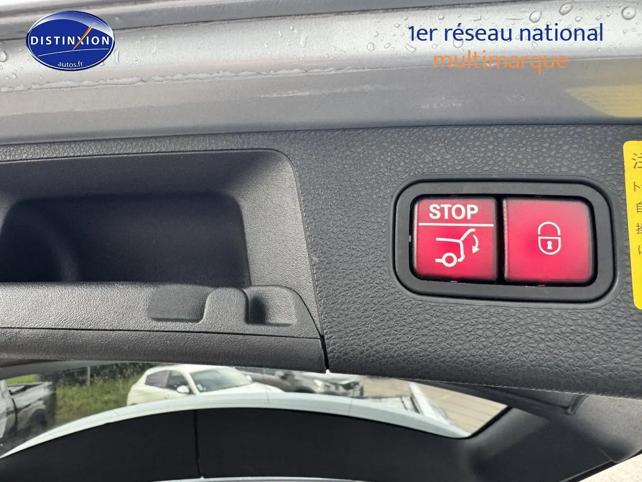 Gros plan sur la commande d'ouverture et de verrouillage du coffre sur un Mercedes GLK noir, vue intérieure du hayon.