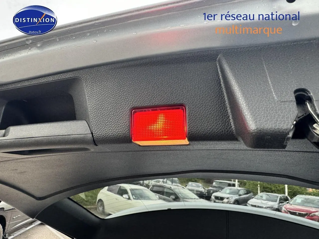 Vue intérieure du hayon ouvert d'un Mercedes GLK noir, mettant en valeur la lumière rouge de sécurité intégrée.