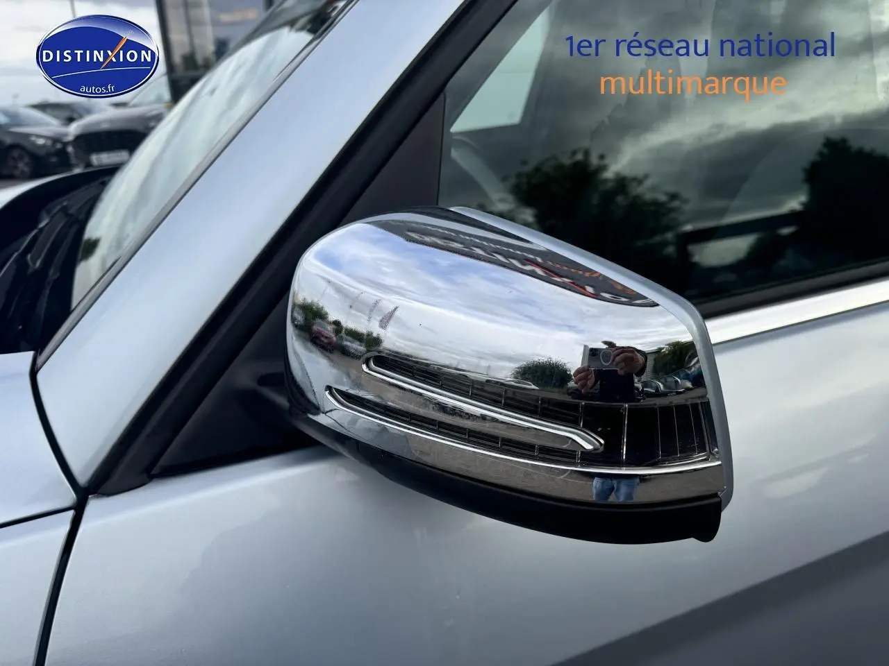 Rétroviseur chromé côté gauche d’un Mercedes GLK noir, vue rapprochée sur la portière avant.