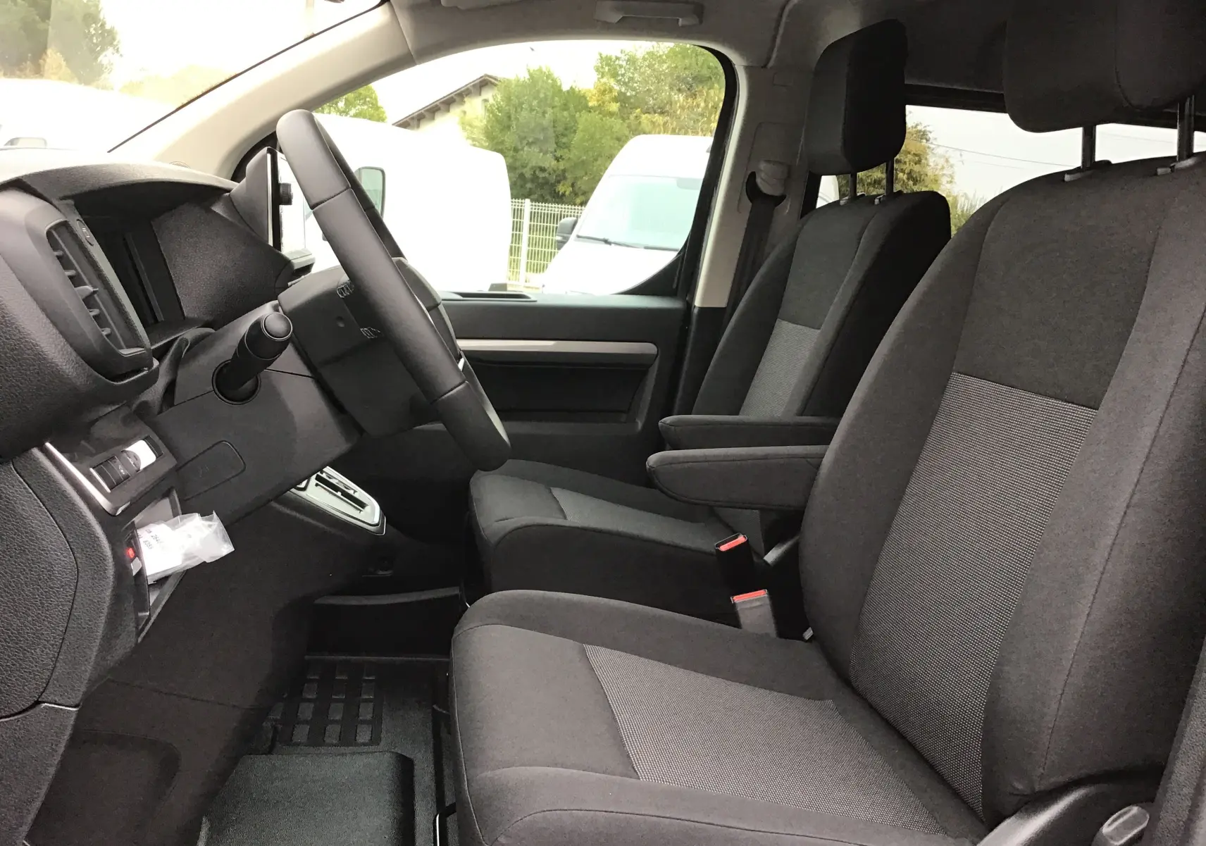 Vue intérieure côté conducteur du Peugeot Expert Cabine Approfondie gris titane, montrant les sièges avant et le volant.
