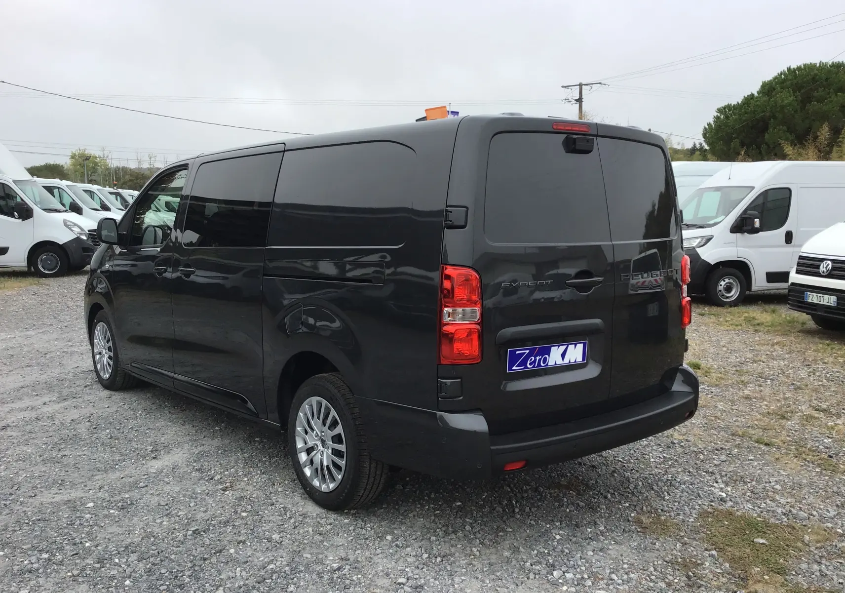Vue 3/4 arrière droite d’un Peugeot Expert cabine approfondie gris titane avec vitres arrière teintées et jantes alliage.