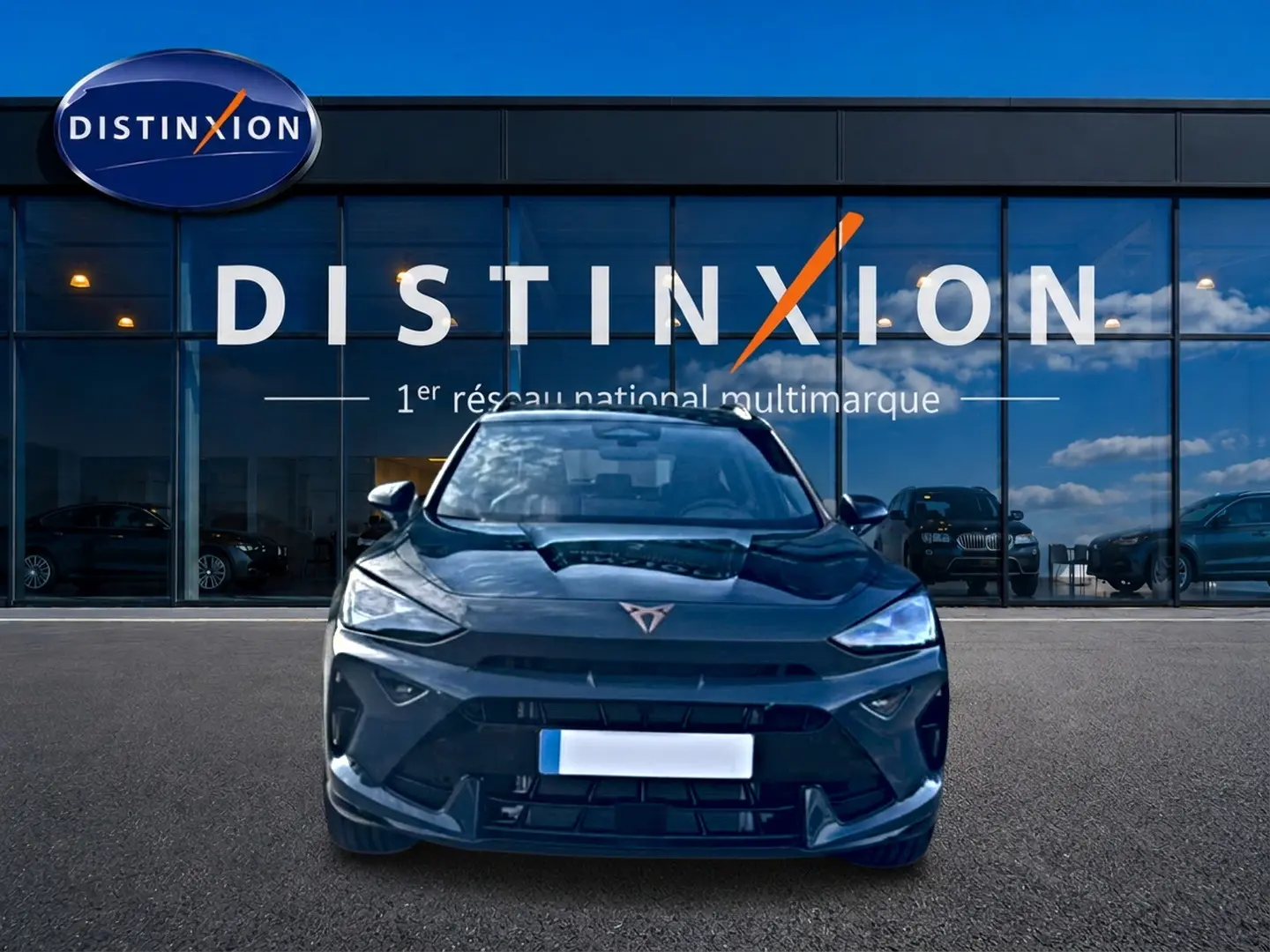 Vue frontale d'un CUPRA Formentor bleu fjord 2026 avec logo distinctif et calandre sportive, devant un showroom Distinxion.