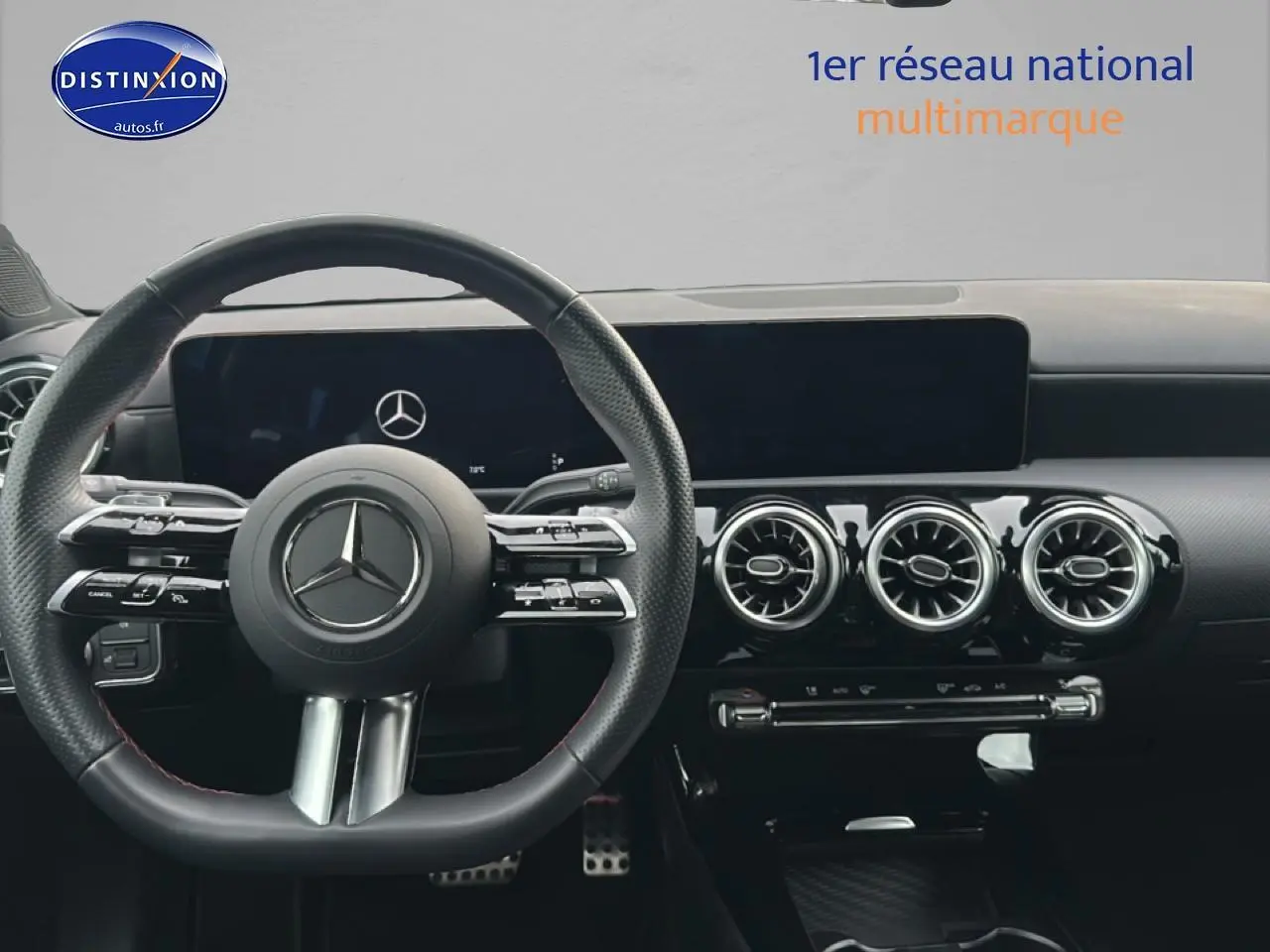 Vue intérieure centrée sur le volant cuir multifonction et la planche de bord noire du Mercedes Classe A 180 AMG Line.