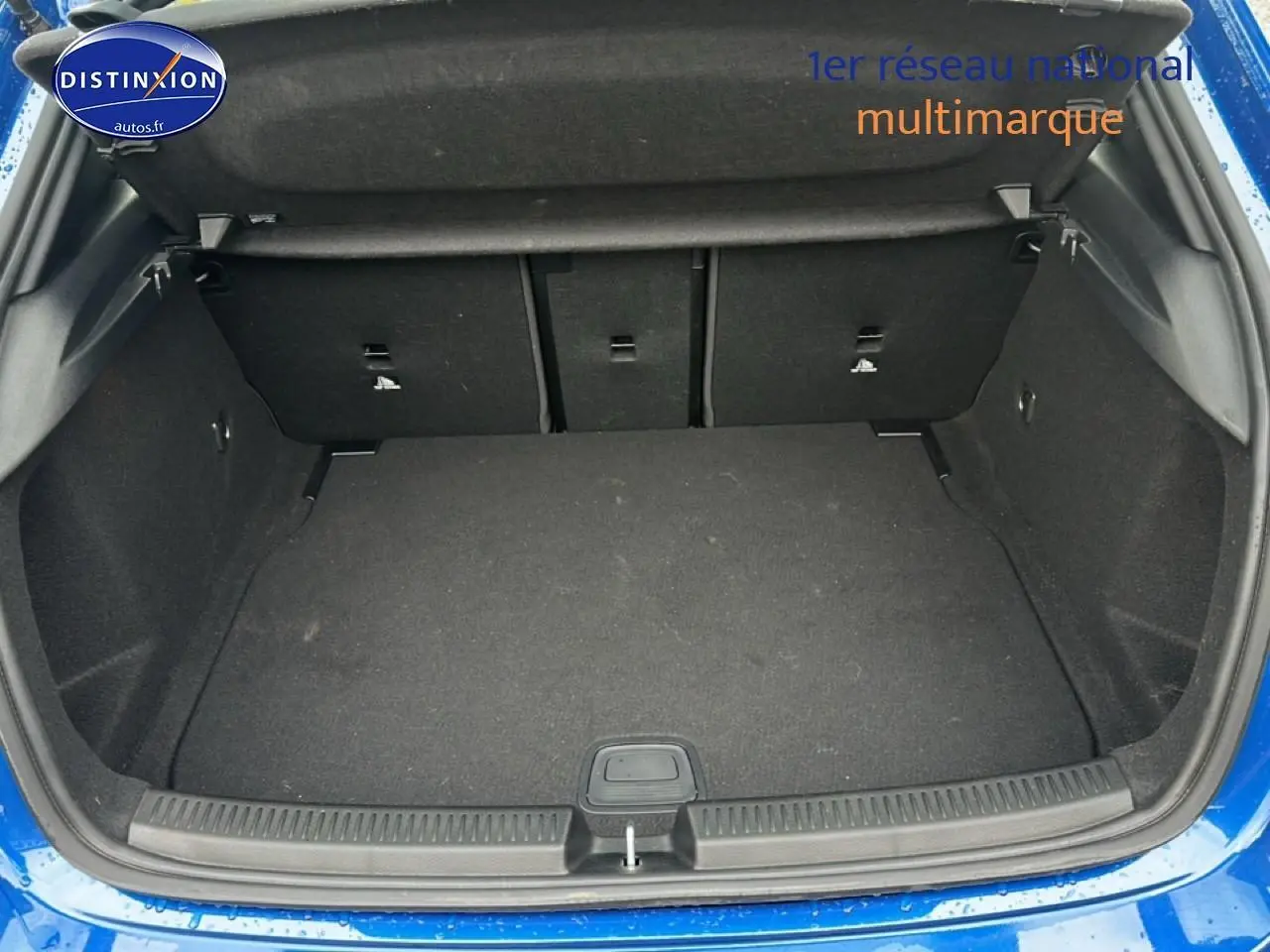 Coffre ouvert vu de l'arrière d'une Mercedes Classe A 180 AMG Line bleu 2024, intérieur noir.