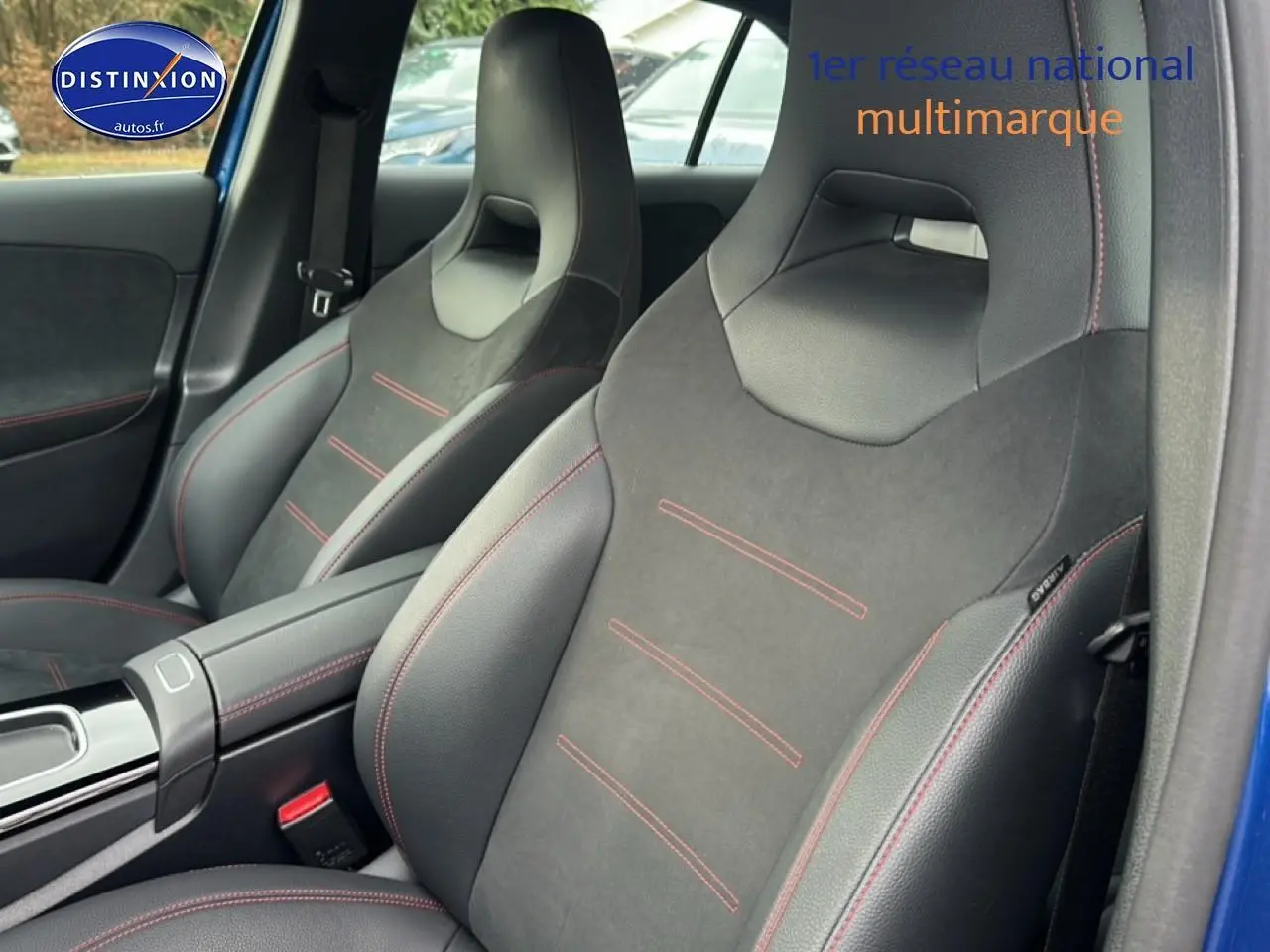 Gros plan sur les sièges avant sport noirs avec surpiqûres rouges dans une Mercedes Classe A 180 AMG Line bleu.