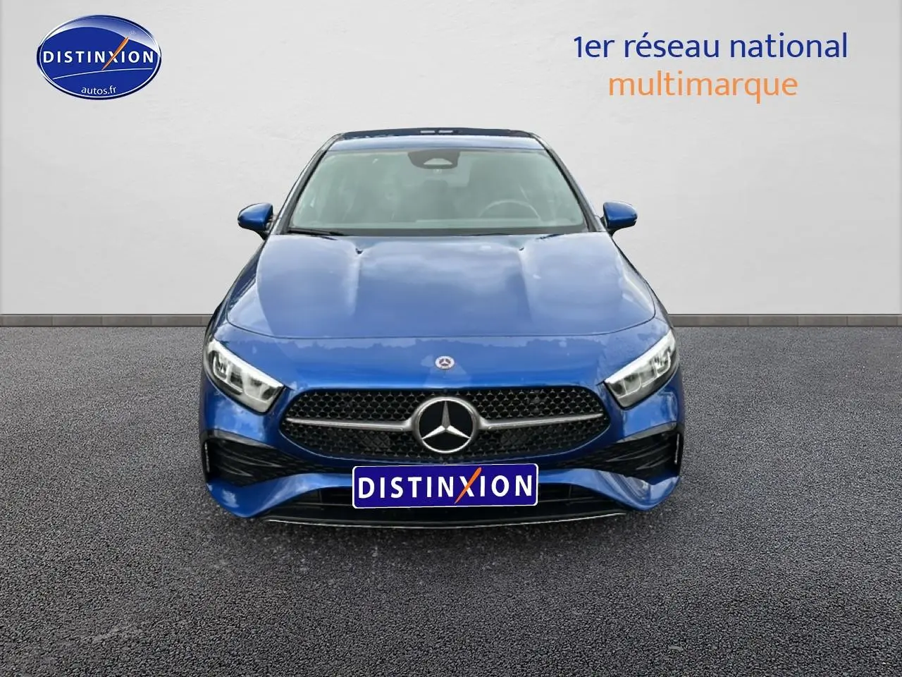 Vue frontale d'une Mercedes Classe A 180 AMG Line bleu avec calandre noire et logo étoile central.