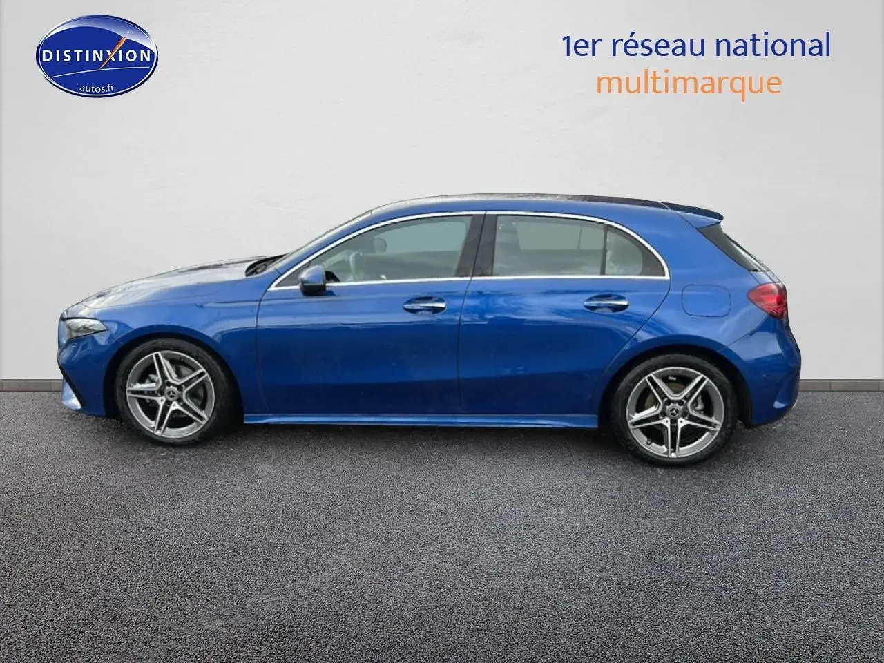 Profil côté gauche d'une Mercedes Classe A 180 AMG Line bleu 2024 avec jantes alliage et poignées couleur carrosserie.