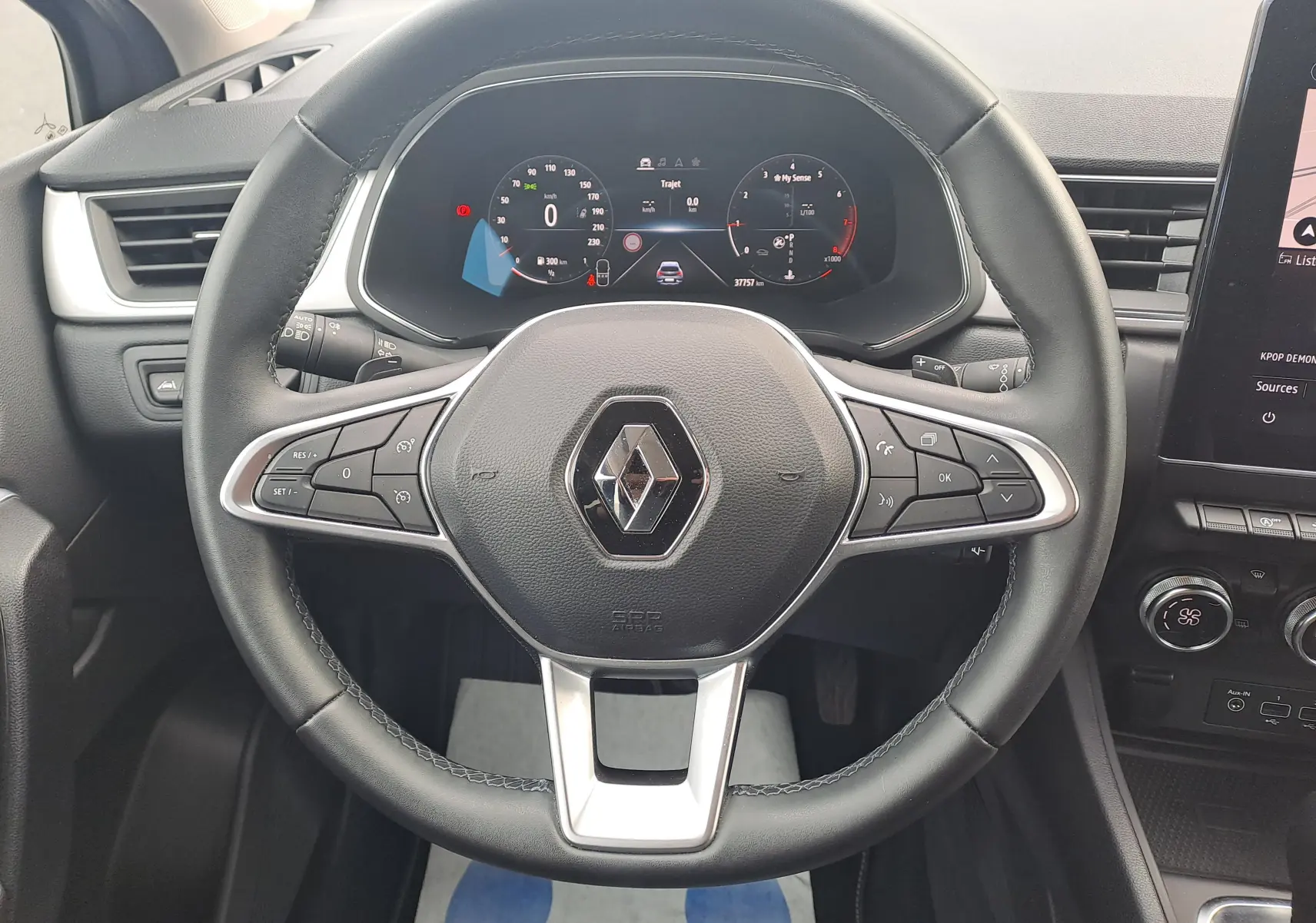 Vue rapprochée du volant noir du Renault Captur 2022 avec tableau de bord numérique et commandes intégrées.