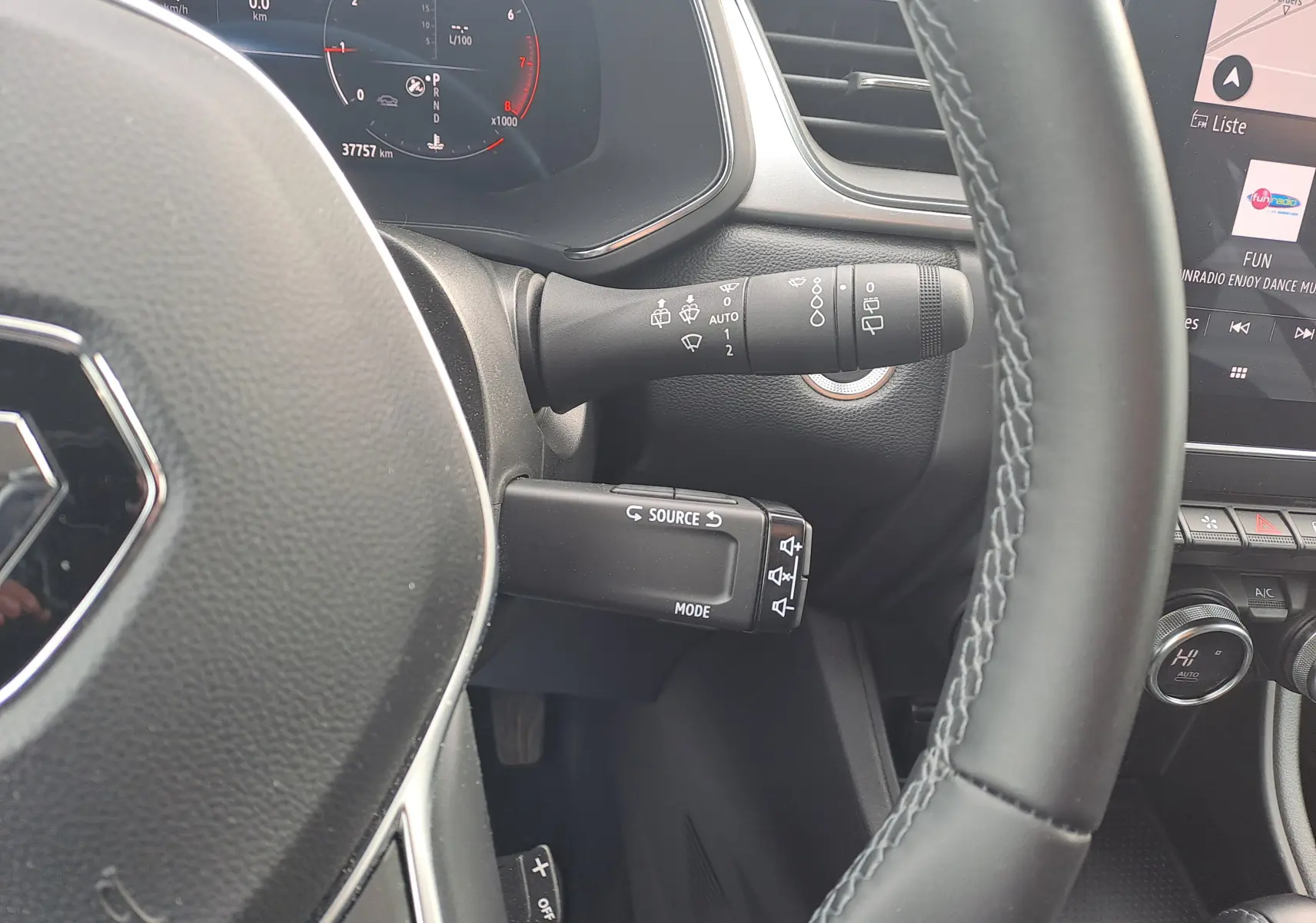 Vue rapprochée du volant et des commandes au volant du Renault Captur gris Cassiopée, avec tableau de bord digital et écran tactile.