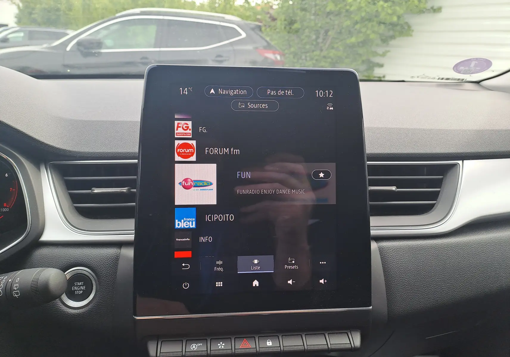 Vue intérieure centrée sur l'écran tactile multimédia du Renault Captur gris cassiopée avec toit noir, affichant les radios.