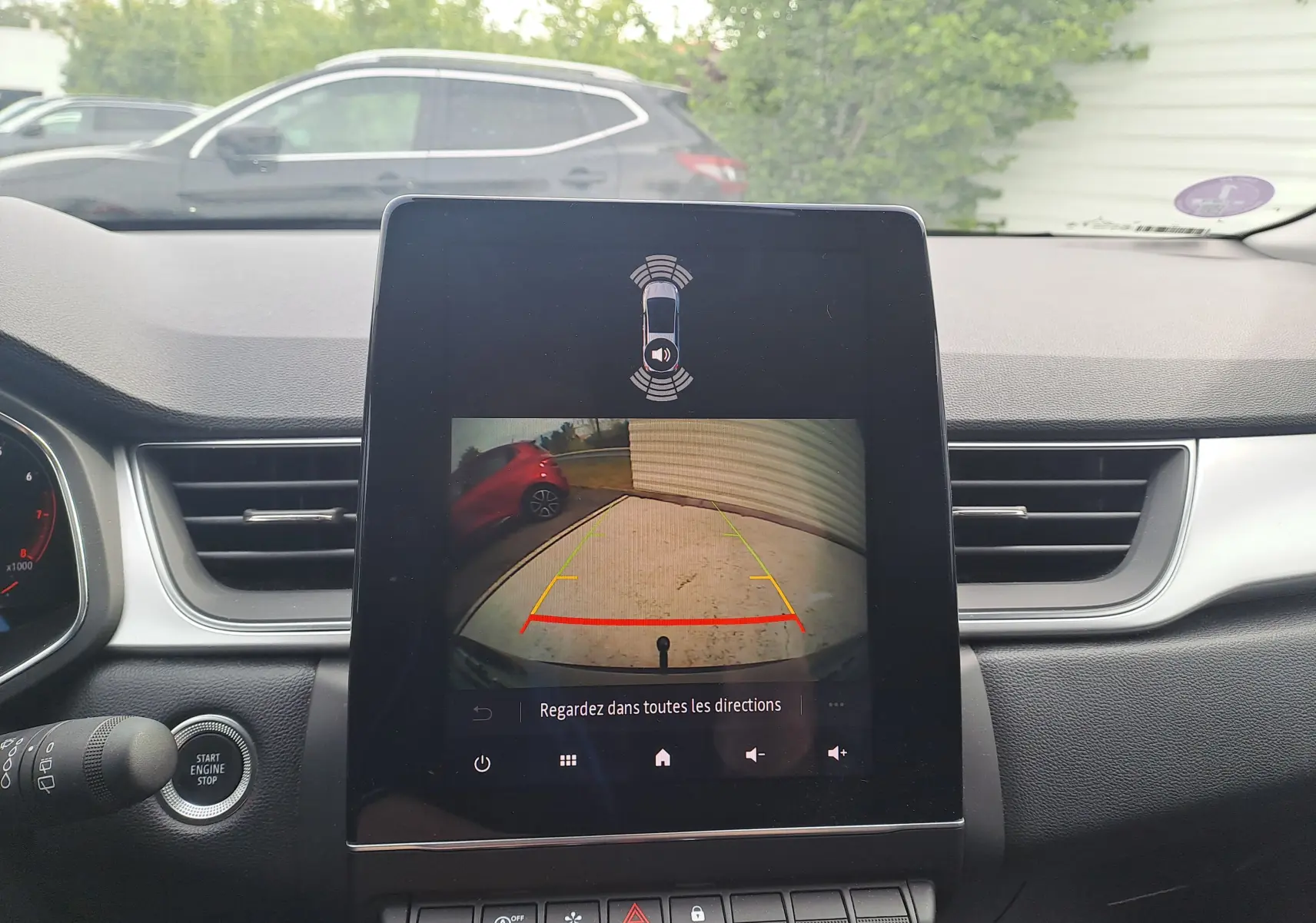 Écran central du tableau de bord du Renault Captur 2022 affichant la caméra de recul avec vue arrière et lignes de guidage colorées.